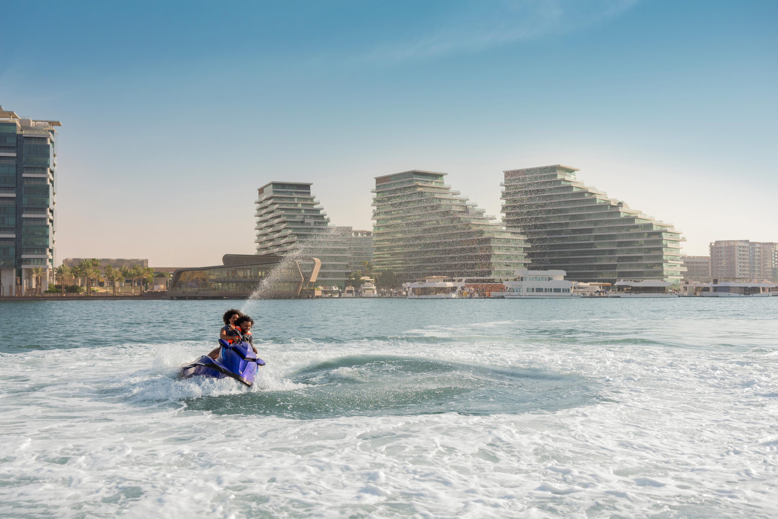 jet skiing on Abu Dhabi waters against skyline