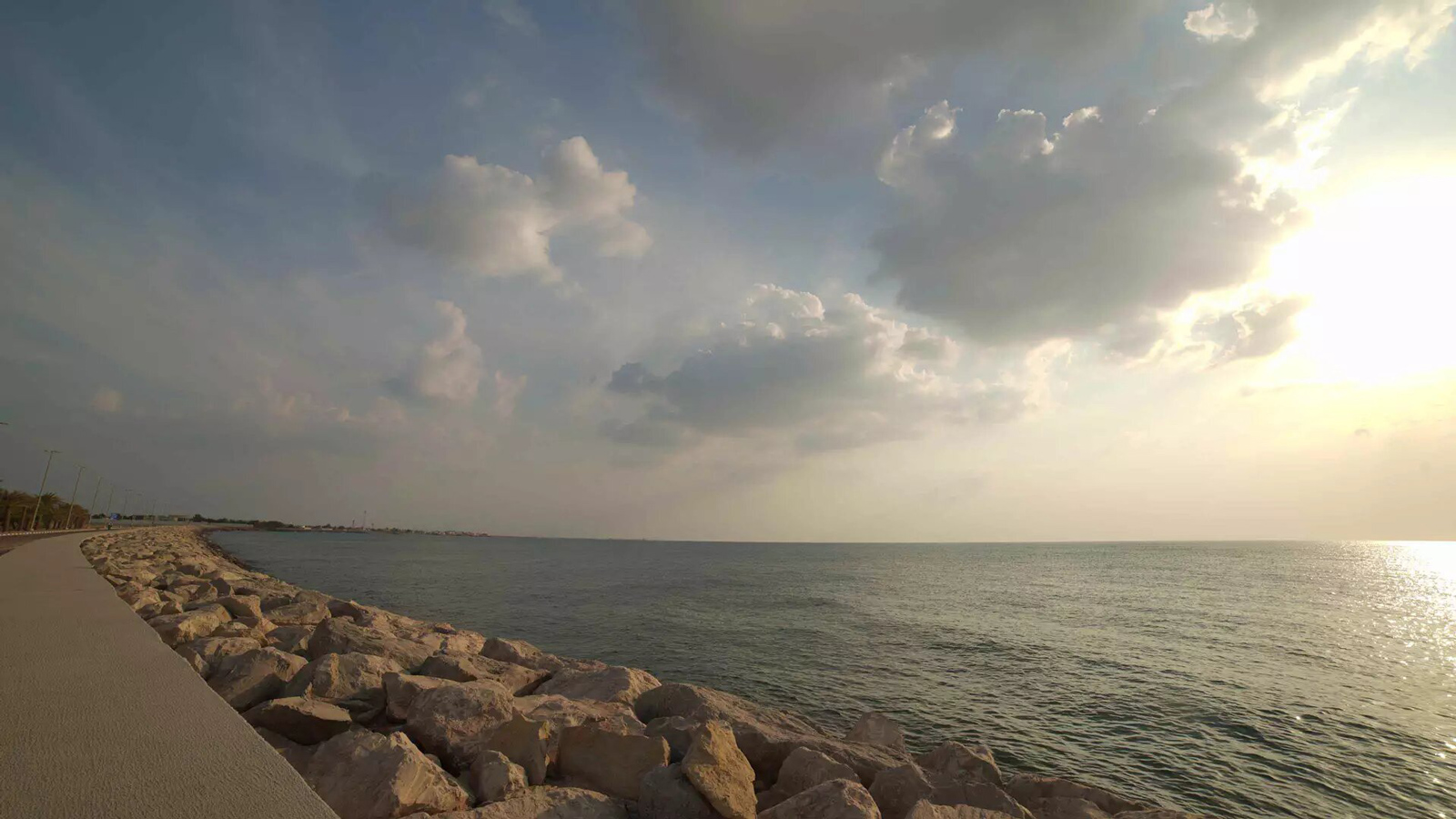 Dalma Island maritime heritage and island life: road, rocks, water, poles, trees, blue and white sky