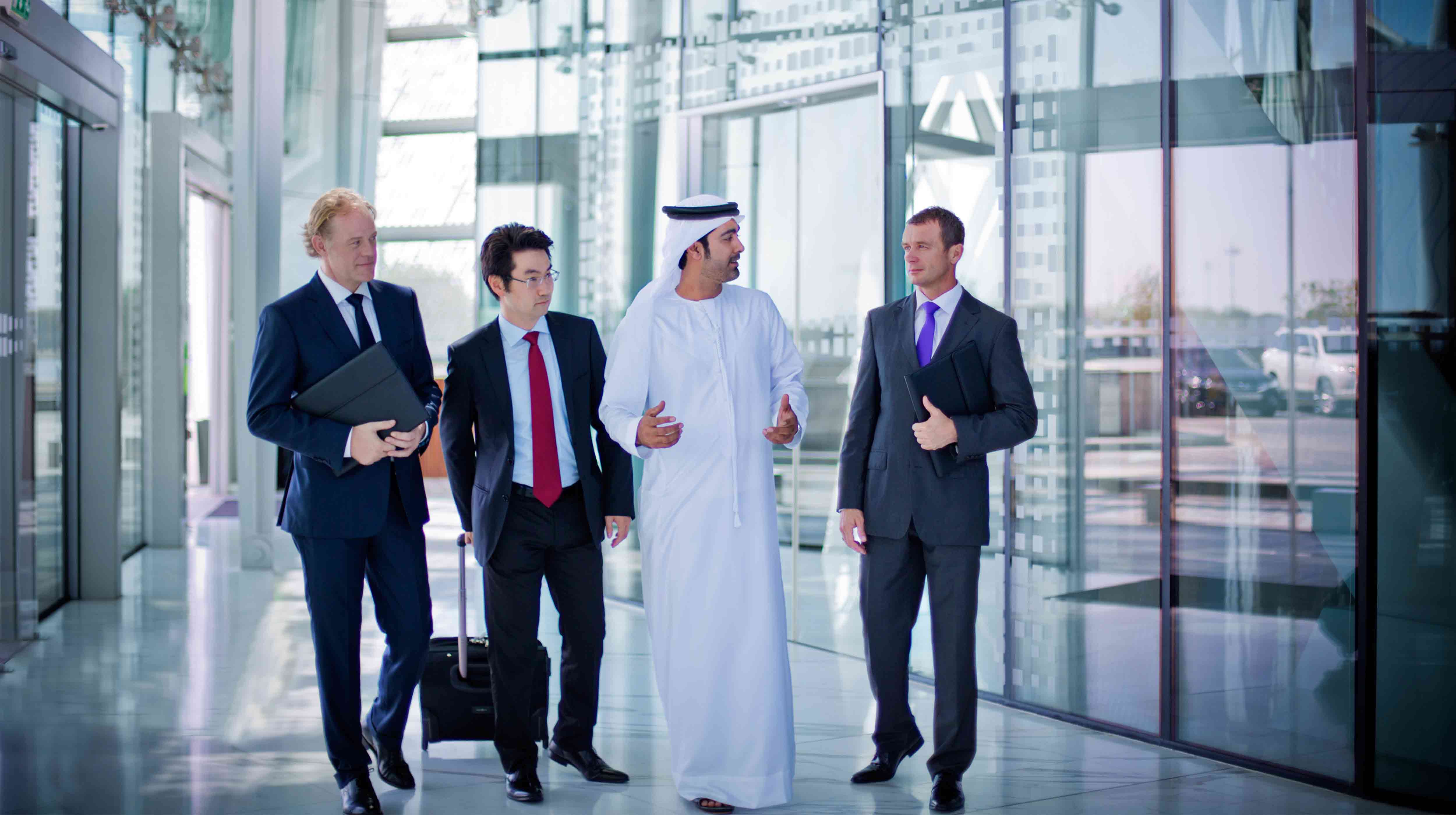 أربع رجال أعمال يجوبون أروقة مكتب أبوظبي للمؤتمرات والمعارض