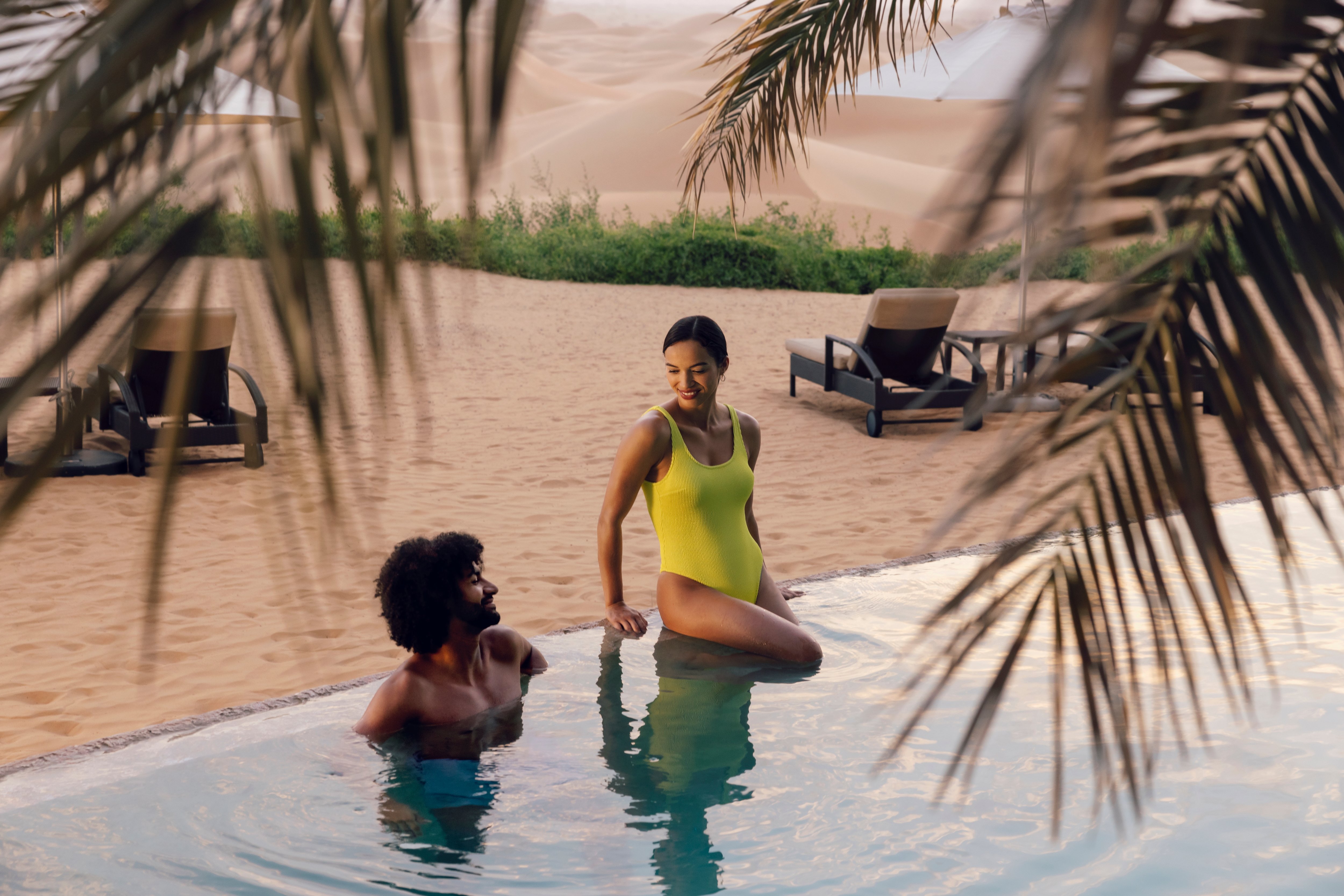Couple enjoying the pool at a Telal Resort desert retreats