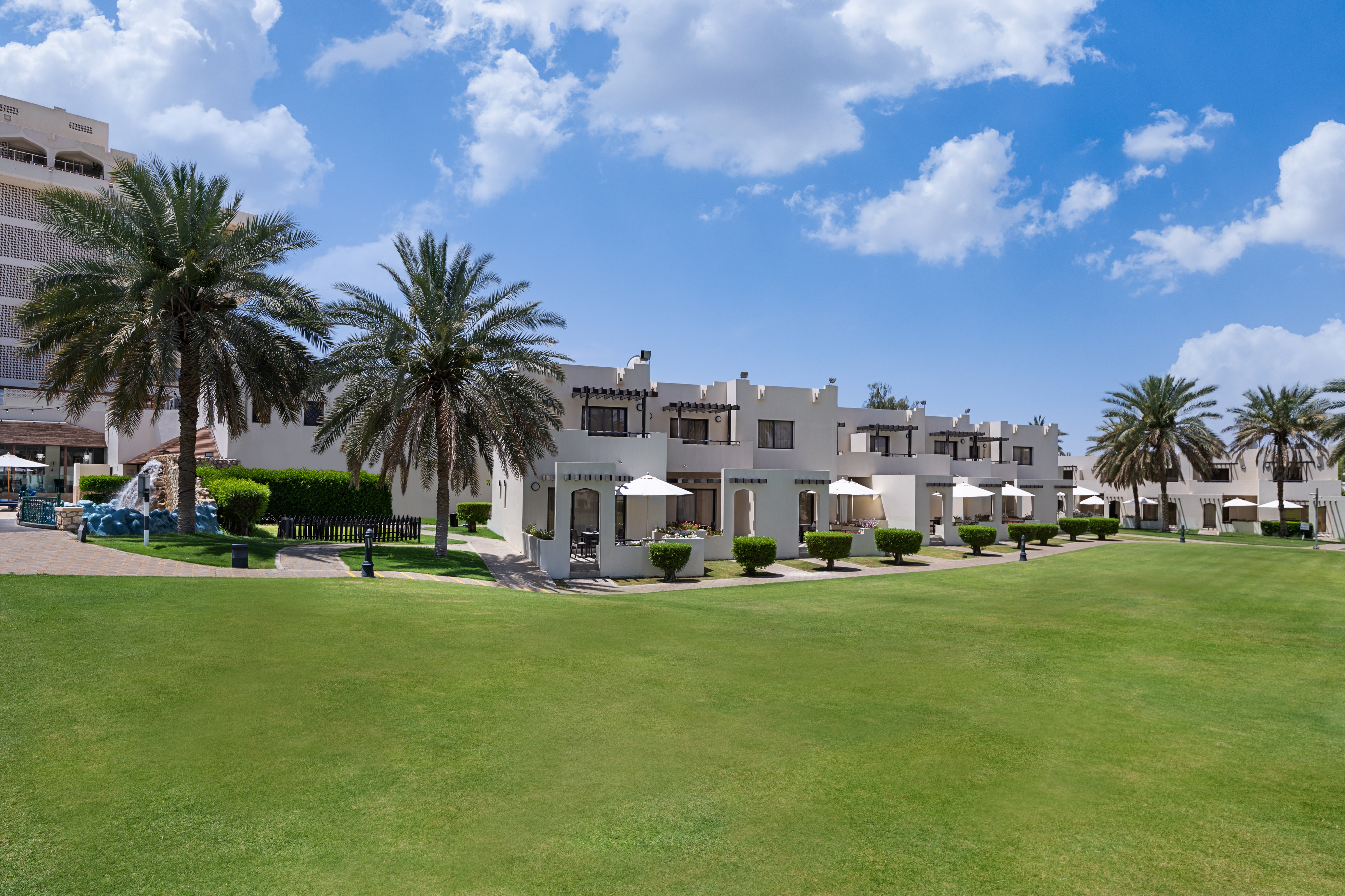 One of Al Ain's resort hotels with small buildings surrounding a green space