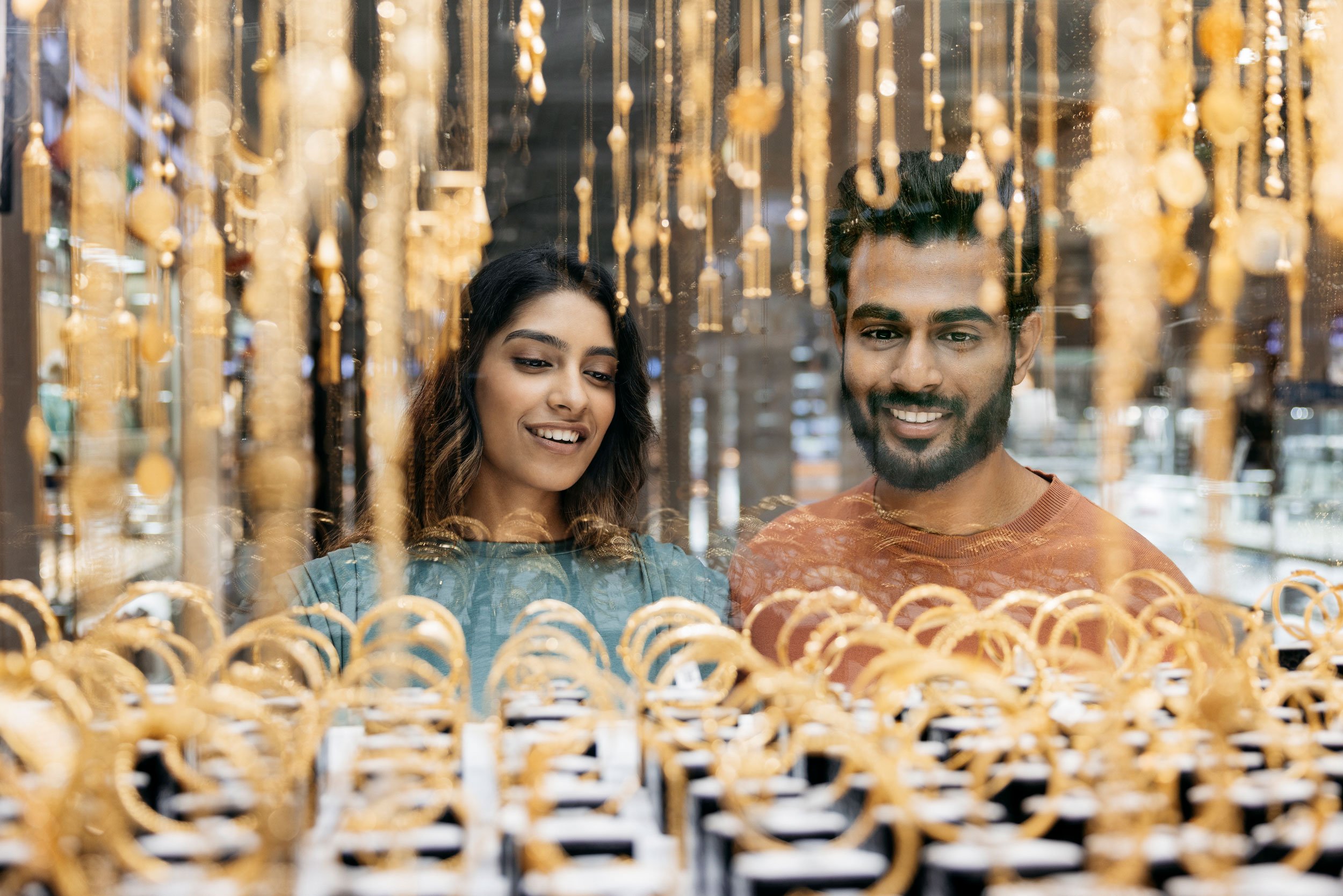 Couple admiring gold jewelry through a shop window in Abu Dhabi.