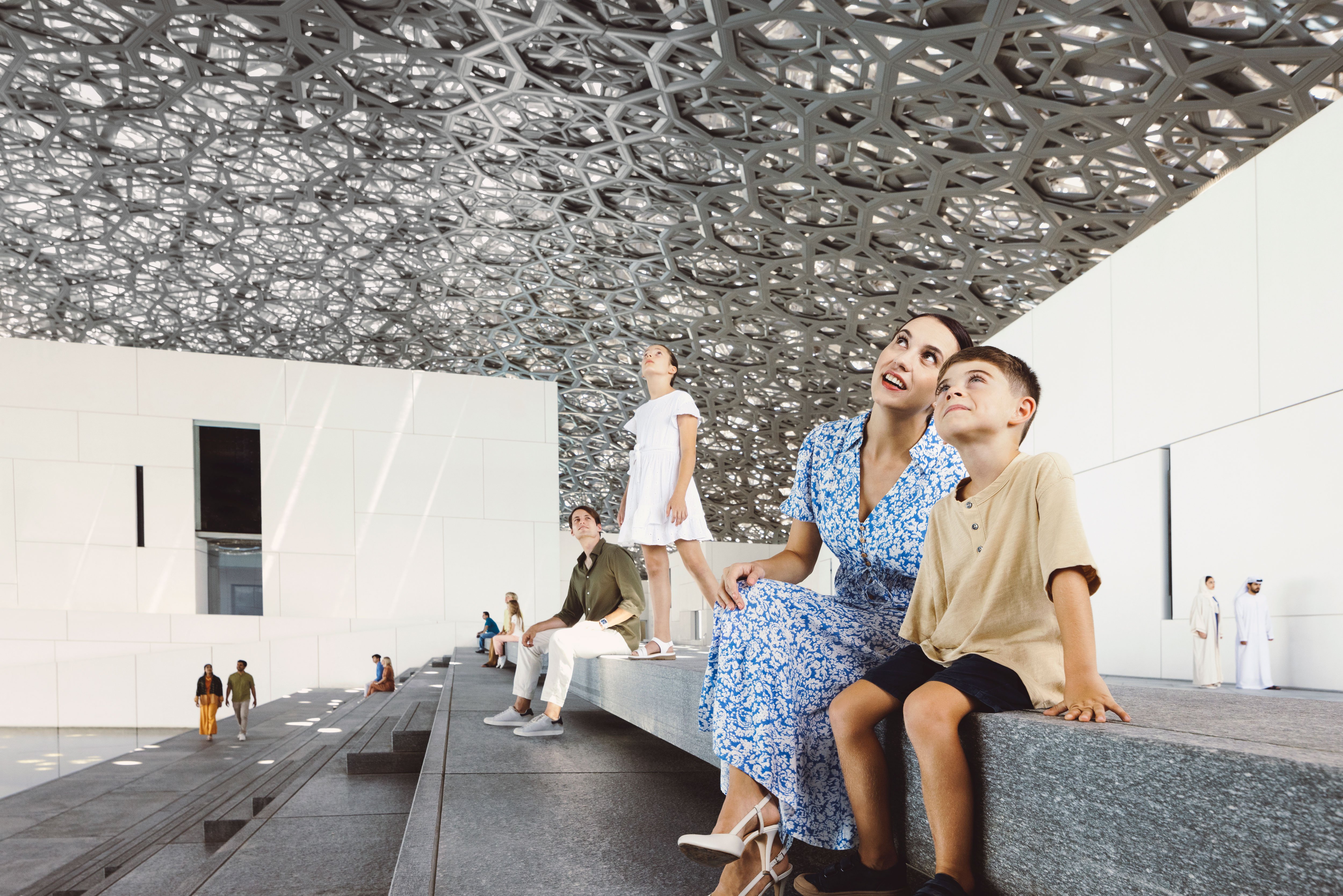 Mother and son admiring the Louvre Abu Dhabi exterior