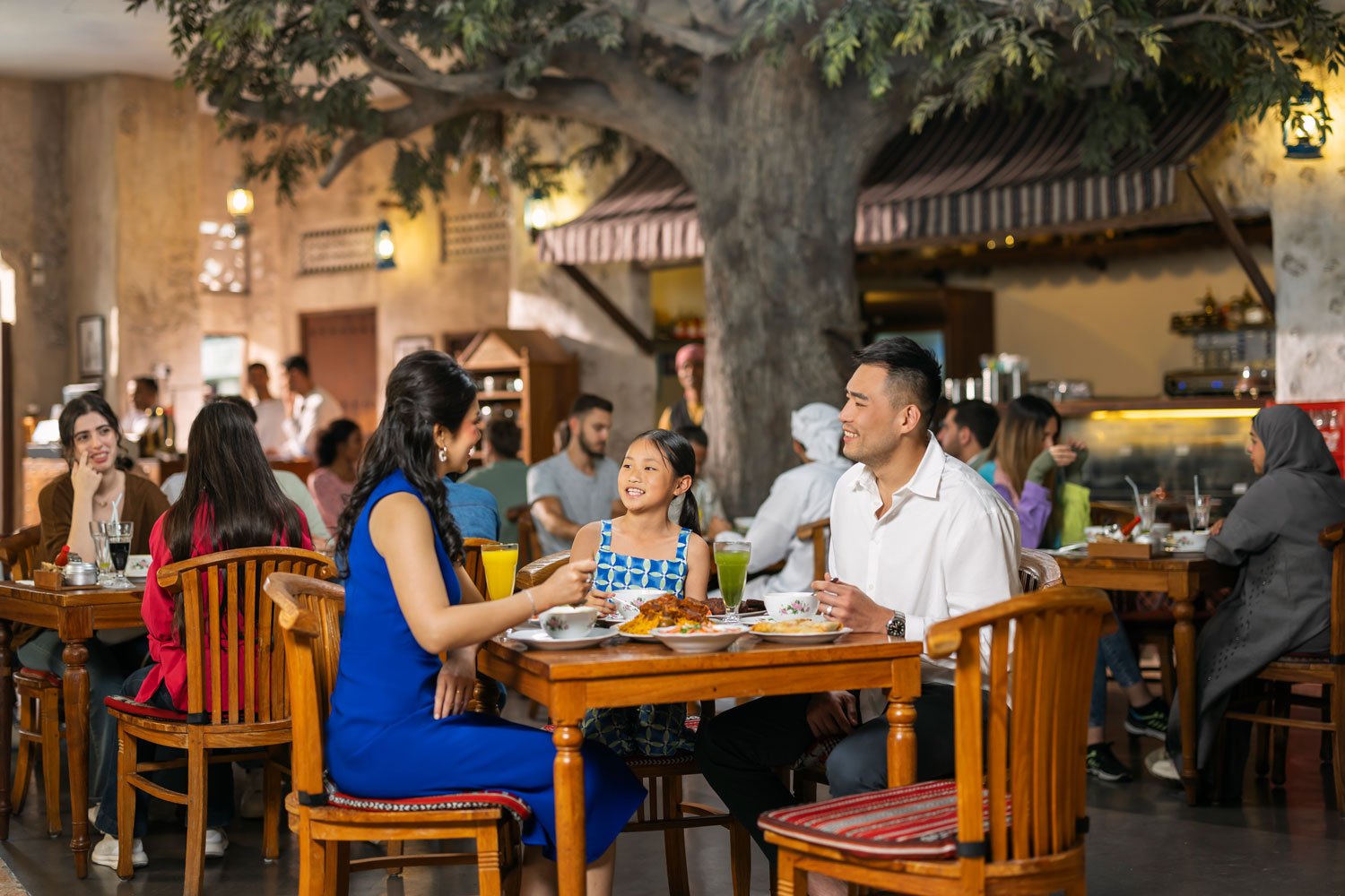 Family enjoying traditional cuisine at a rustic-style restaurant in Abu Dhabi.