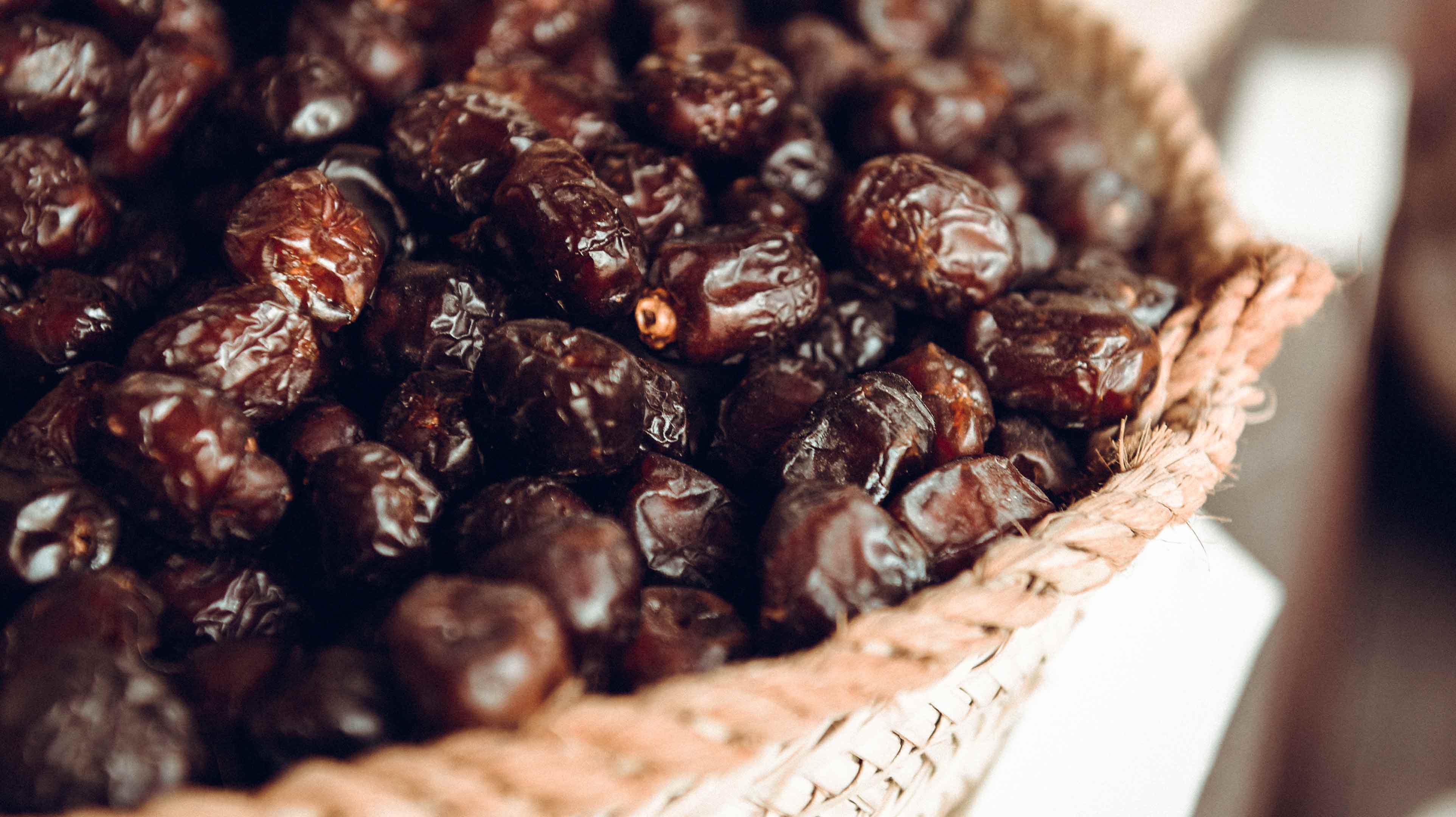 Dark brown dates in a wicker basket to be served with coffee as part of Emirati traditions