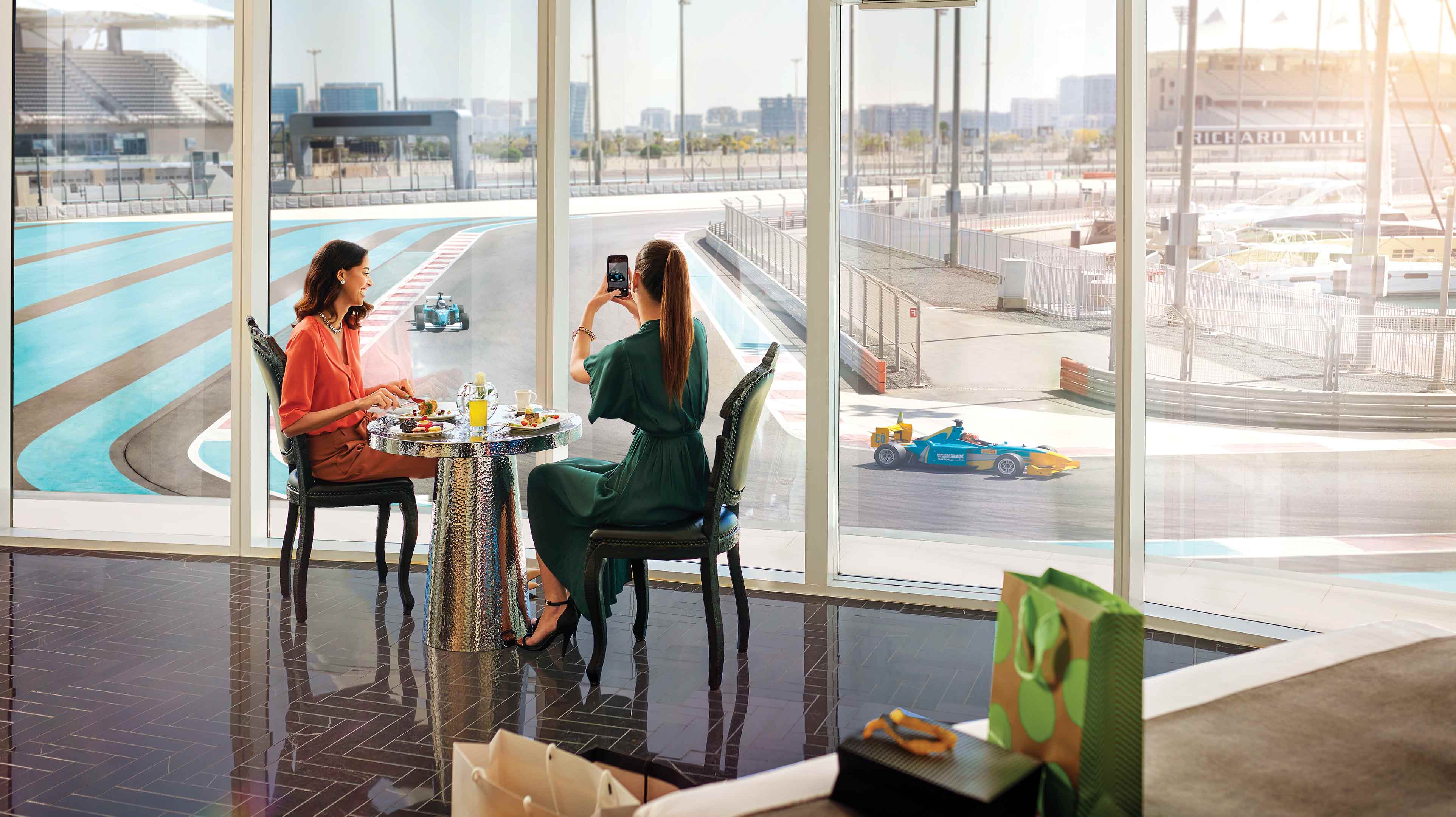 Two female friends dining at the W Abu Dhabi Yas Island overlooking the racetracks
