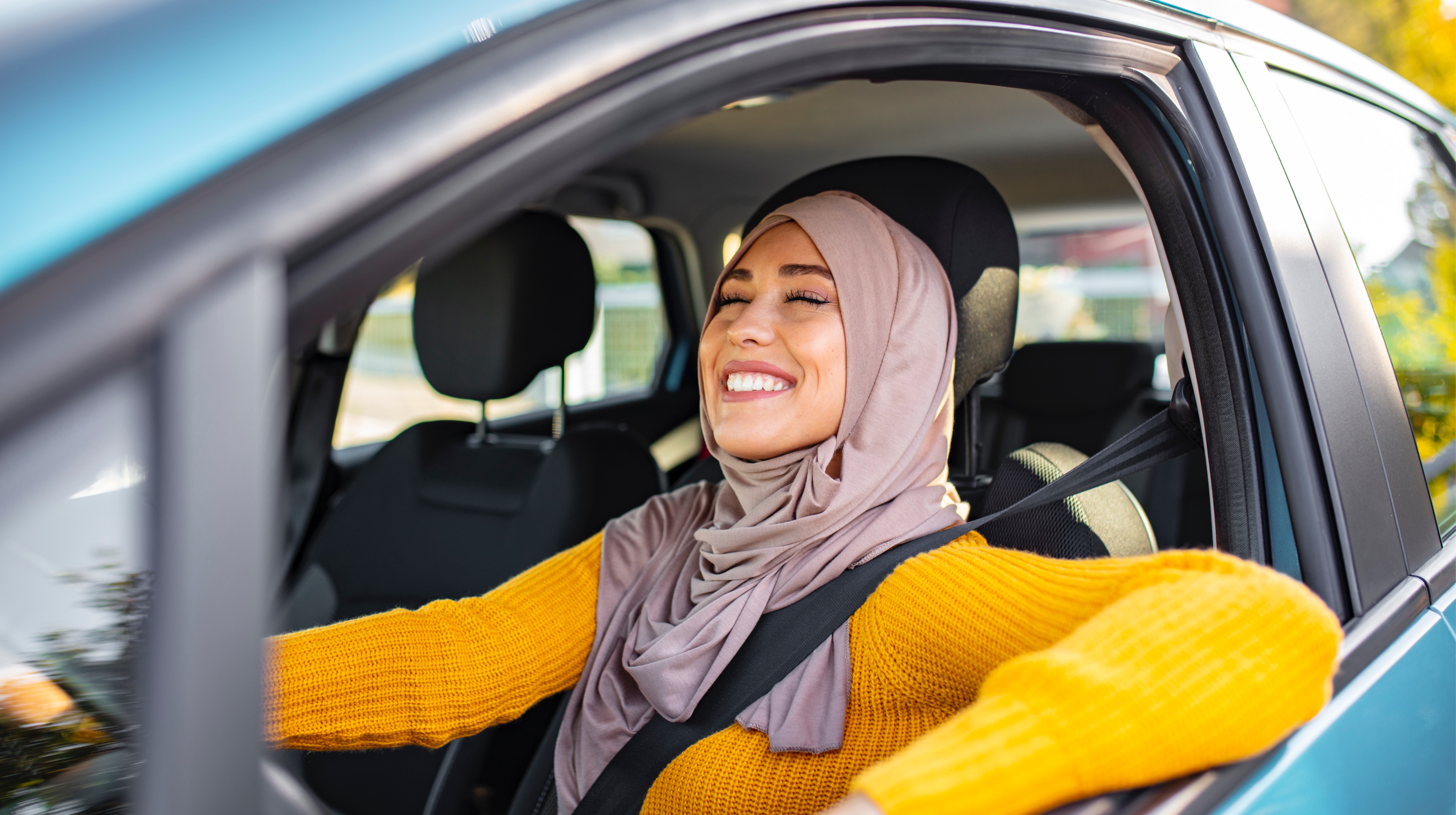 Beautiful woman in a hijab driving her car around the Emirate of Abu Dhabi