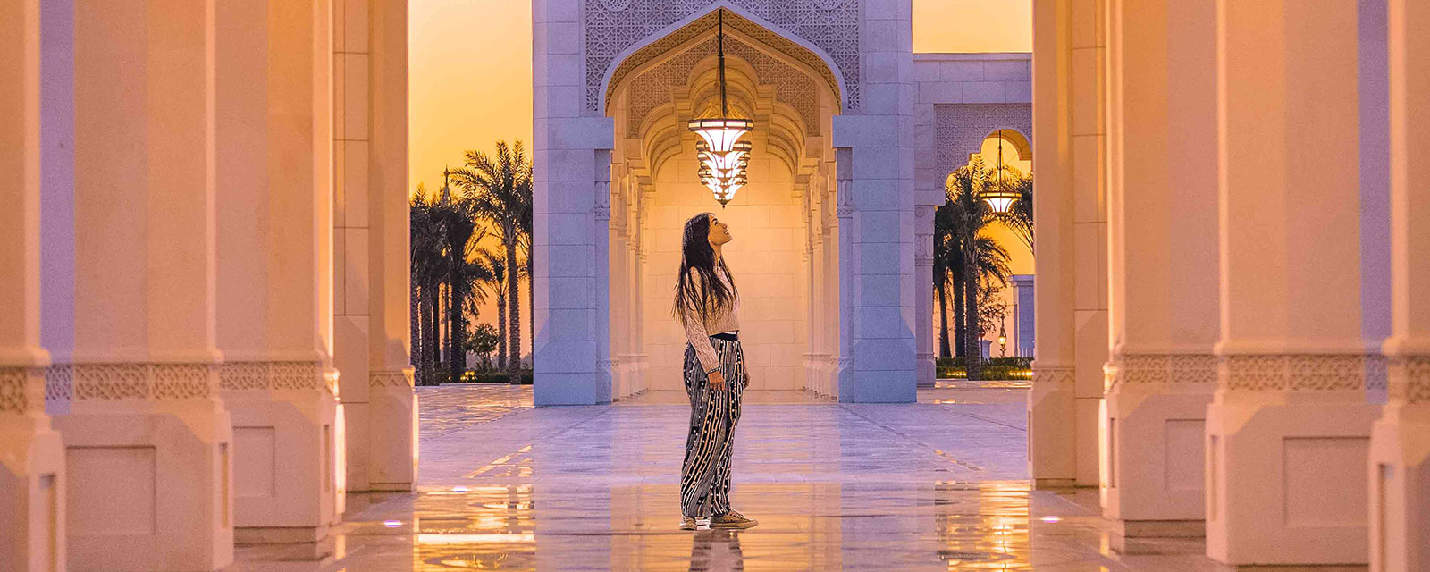  Sous les arches majestueuses de Qasr Ql Watan, une silhouette contemplative savoure le coucher du soleil à Abu Dhabi, un moment tout bonnement magique.