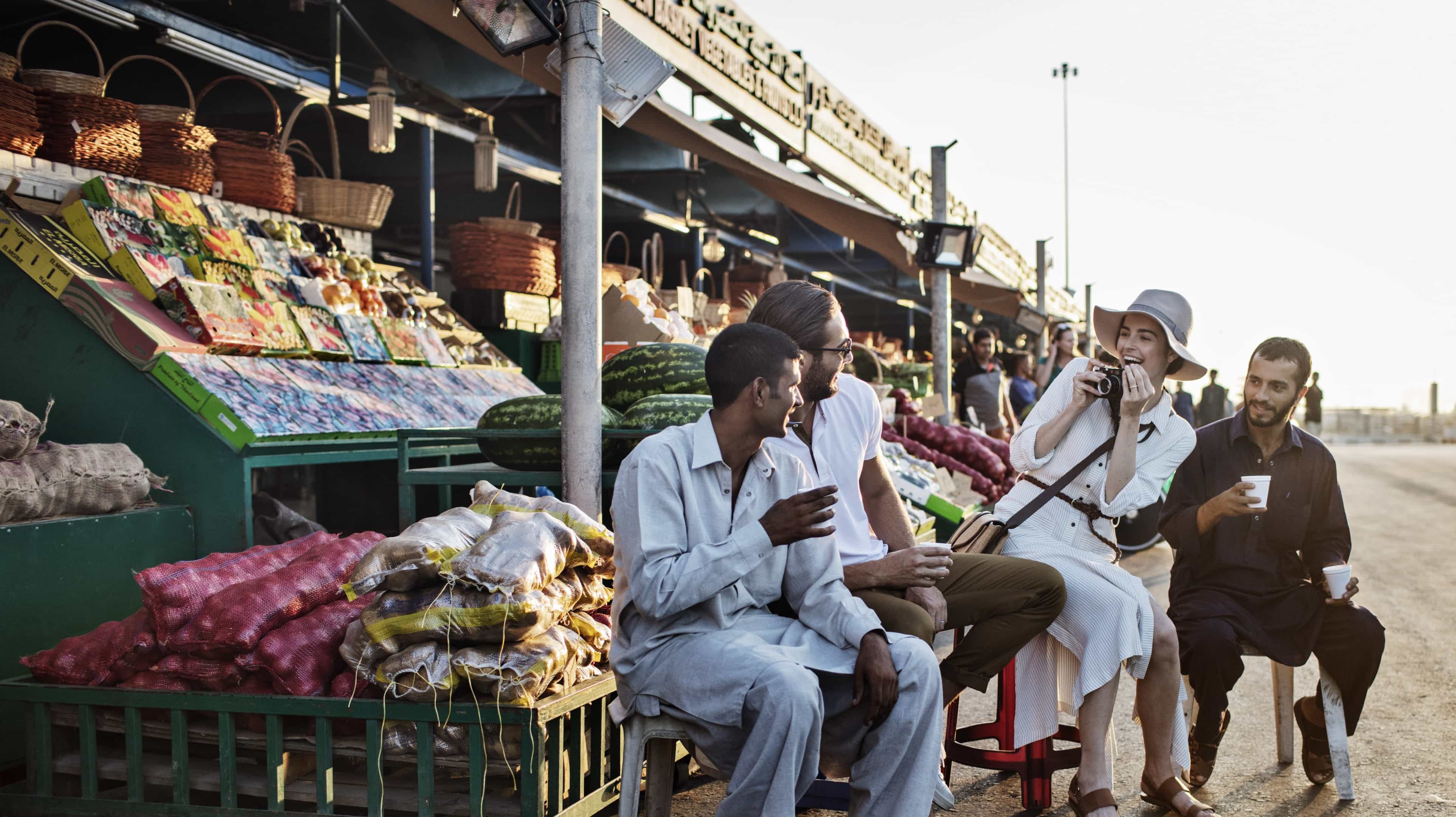 امرأة تقوم بالتصوير في أسواق الخضار والفاكهة في ميناء أبوظبي