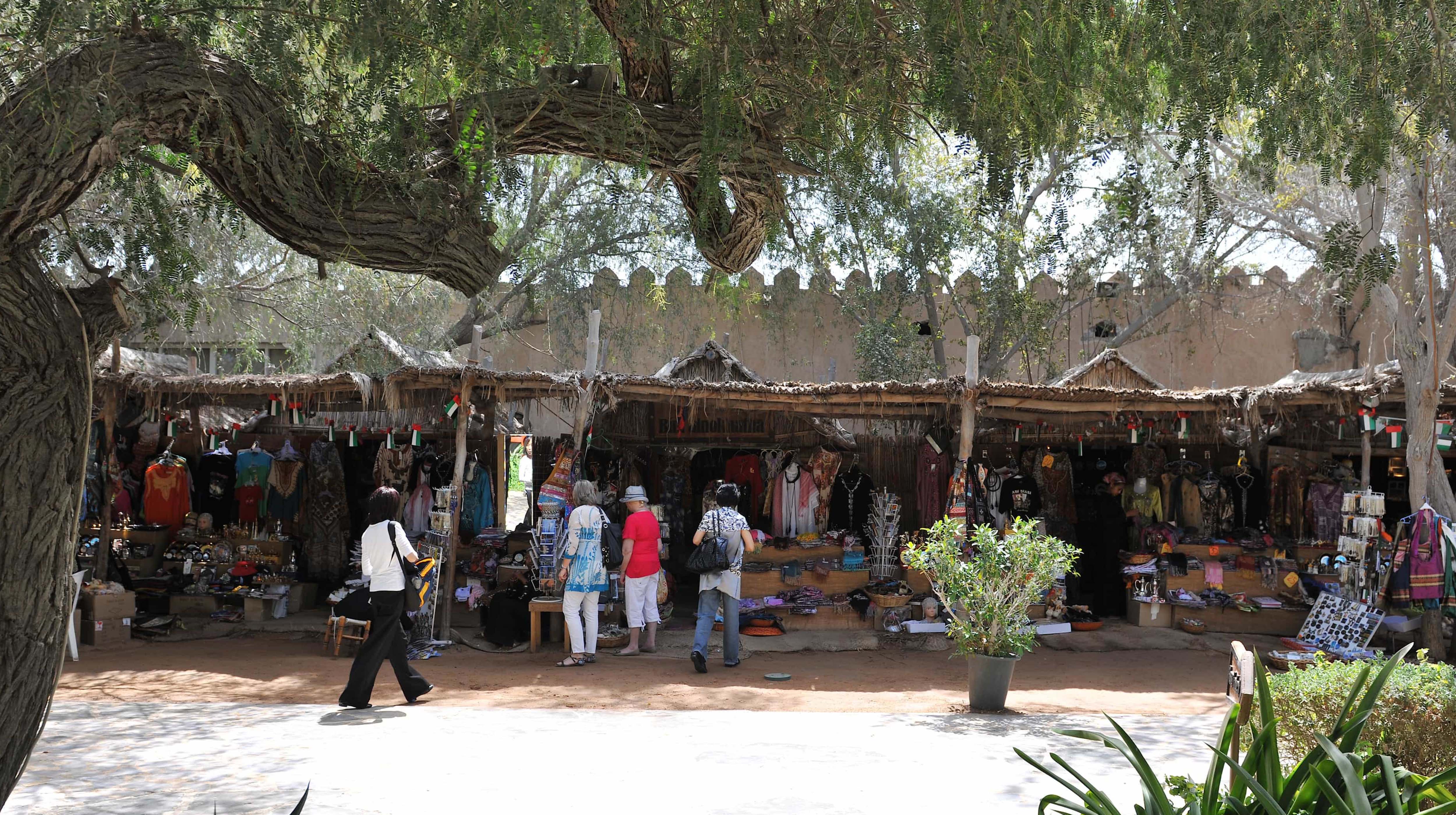 Tourists shopping for souvenirs at the traditional market in Heritage Village