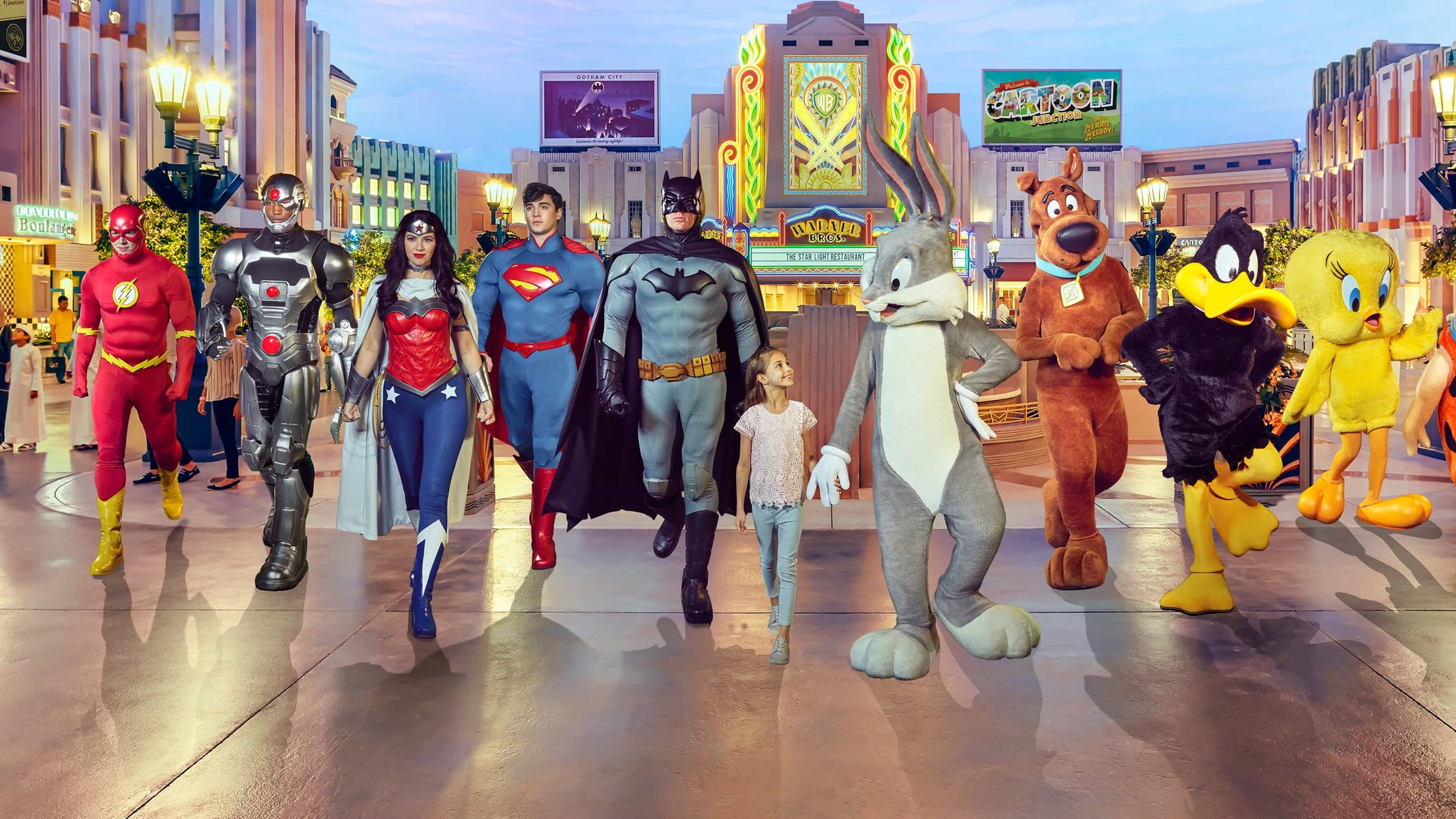 Una bambina avanza felice dando la mano al personaggio di Bugs Bunny e passeggiando insieme ad alcuni dei più famosi supereroi e dei protagonisi dei cartoni della Warner Bros al Warner Bros World Abu Dhabi