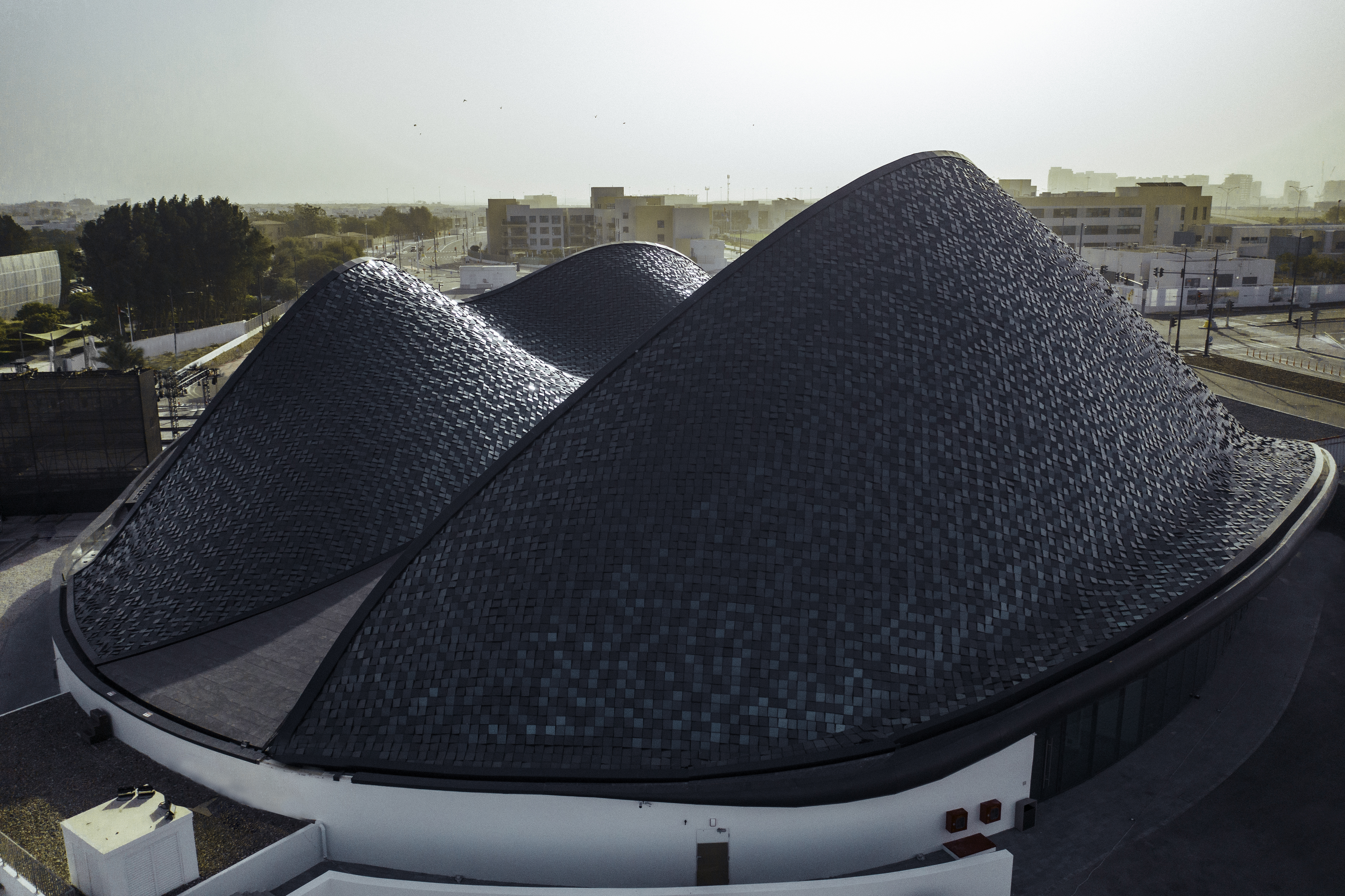Vista dall'alto del moderno edificio del Berklee College of Music di Abu Dhabi con il tetto modellato come dune di sabbia