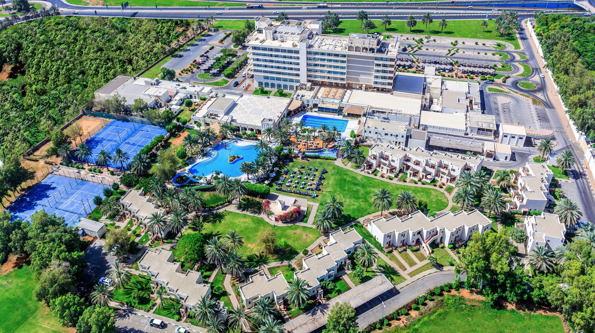 Luftaufnahme des Radisson Blu Resorts in Al Ain mit Pools und Tennisplätzens