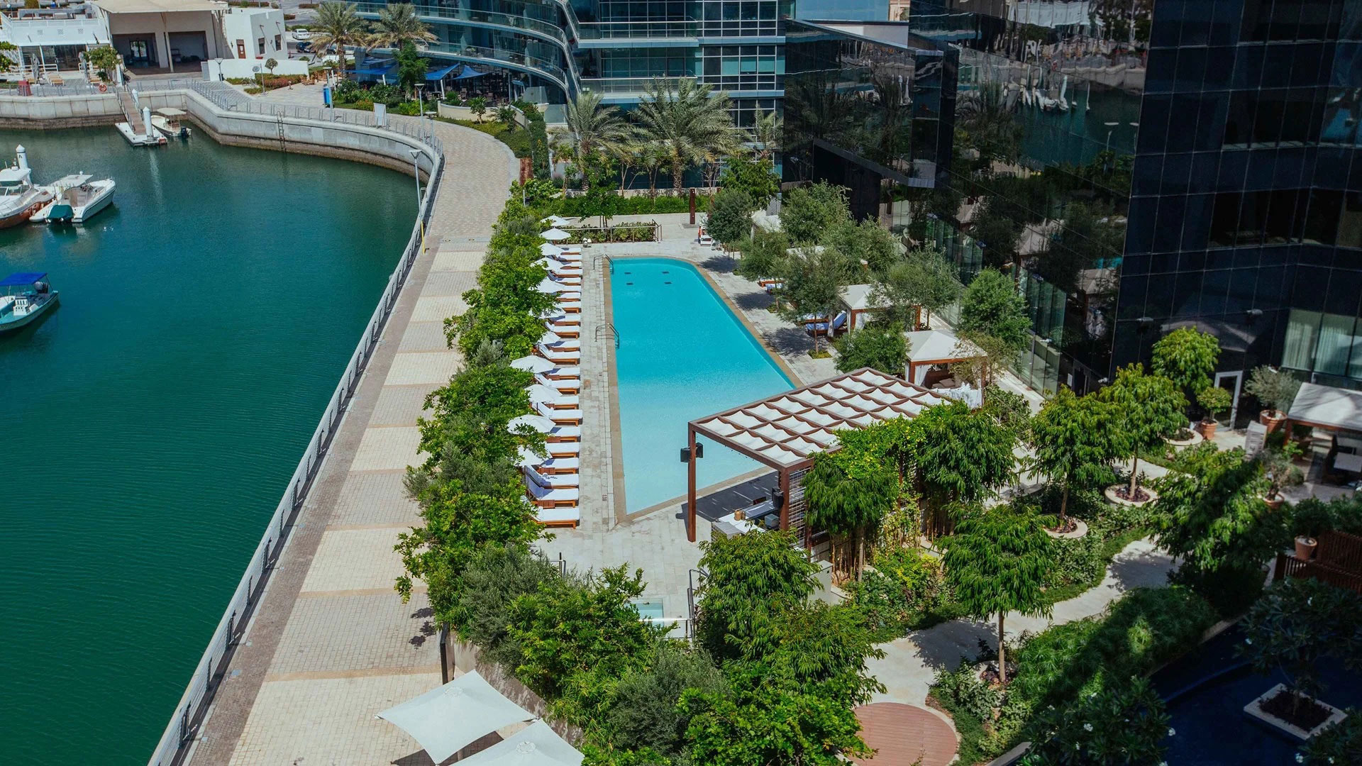Frau lächelt beim Schwimmen im Pool des Abu Dhabi Edition Hotels