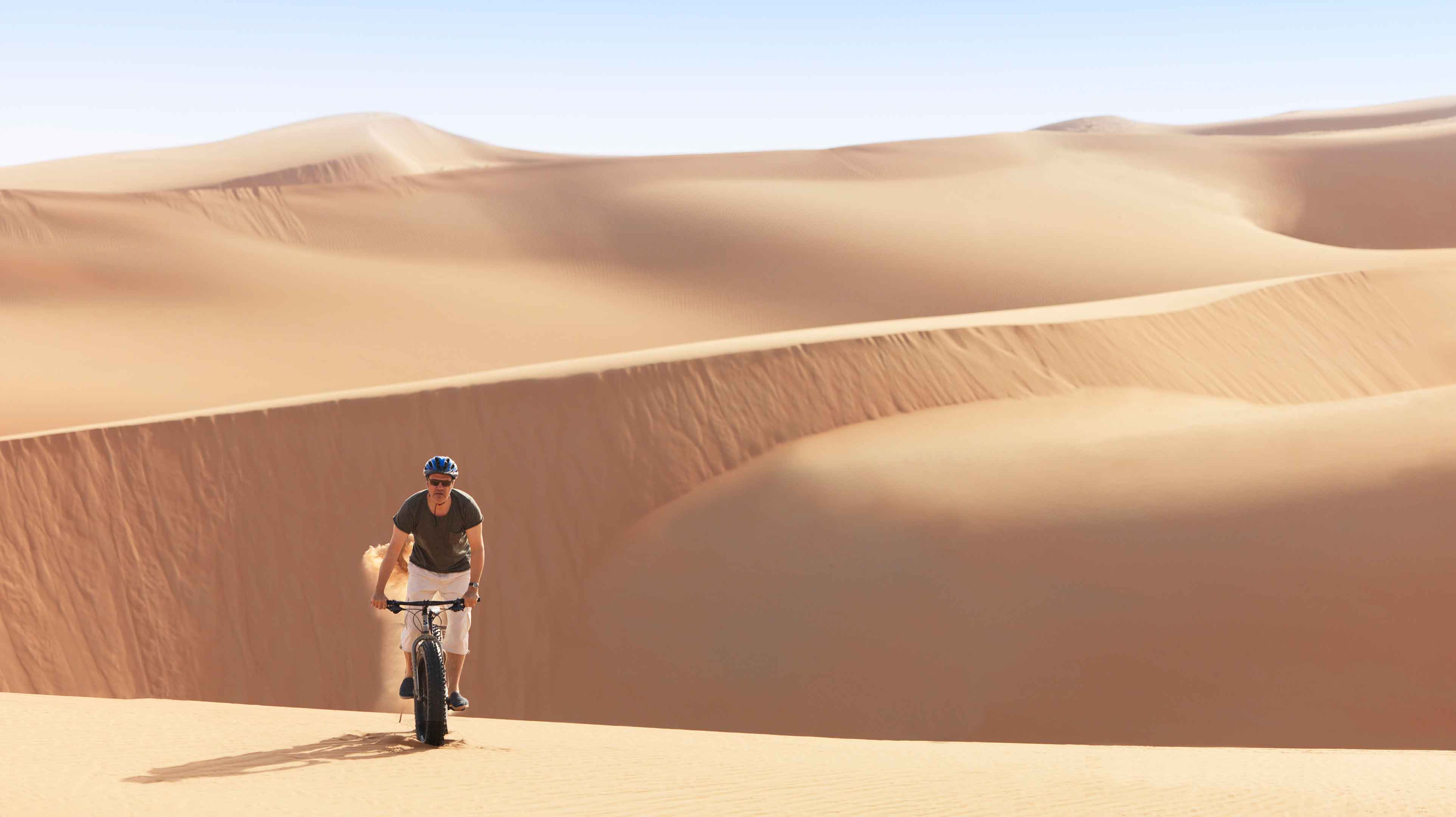4. Fat biking down some of the world’s tallest desert dunes