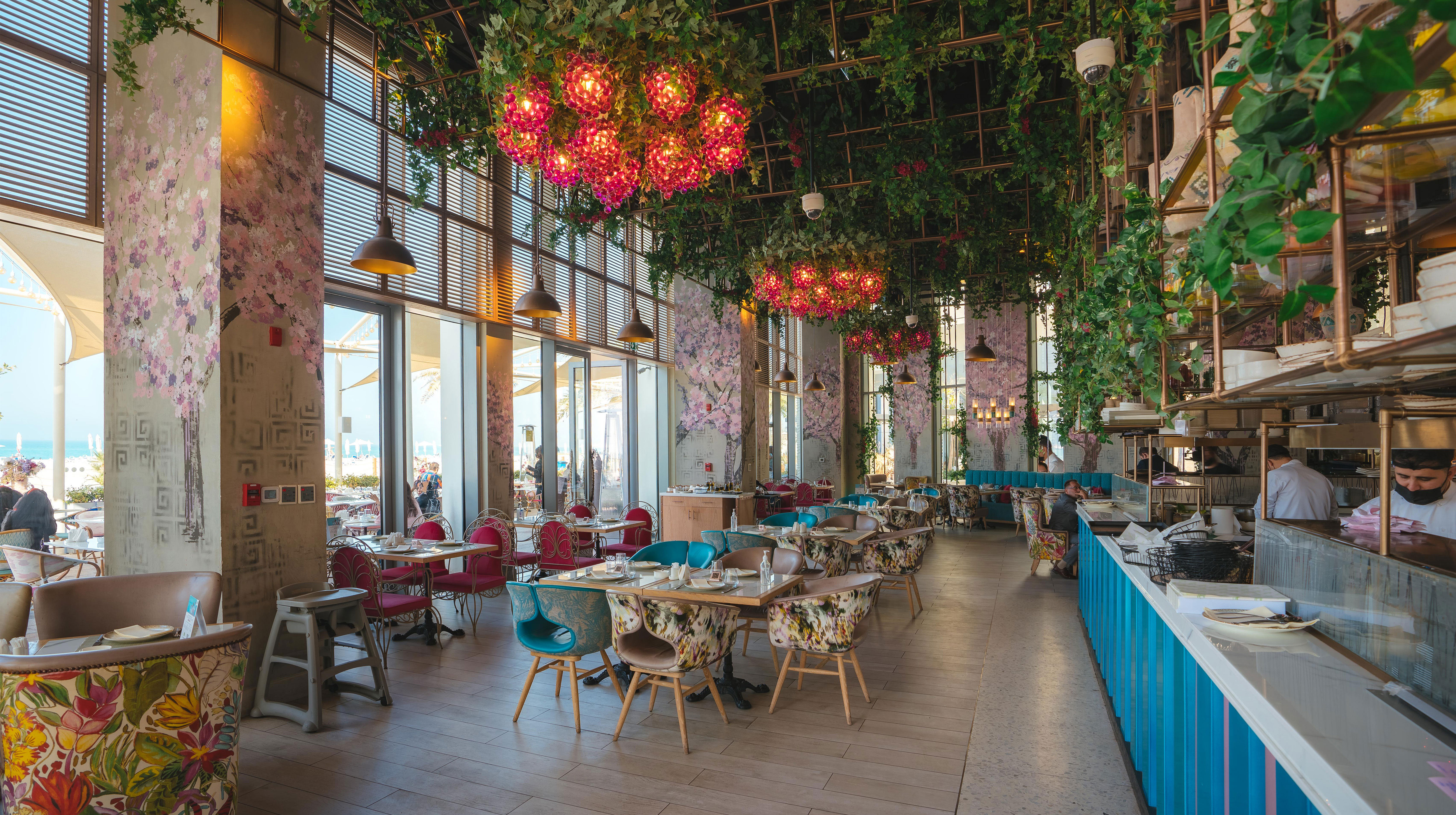 Sala da pranzo con tapezzerie fiorite e piante al soffitto nel ristorante Beirut Sur Mer