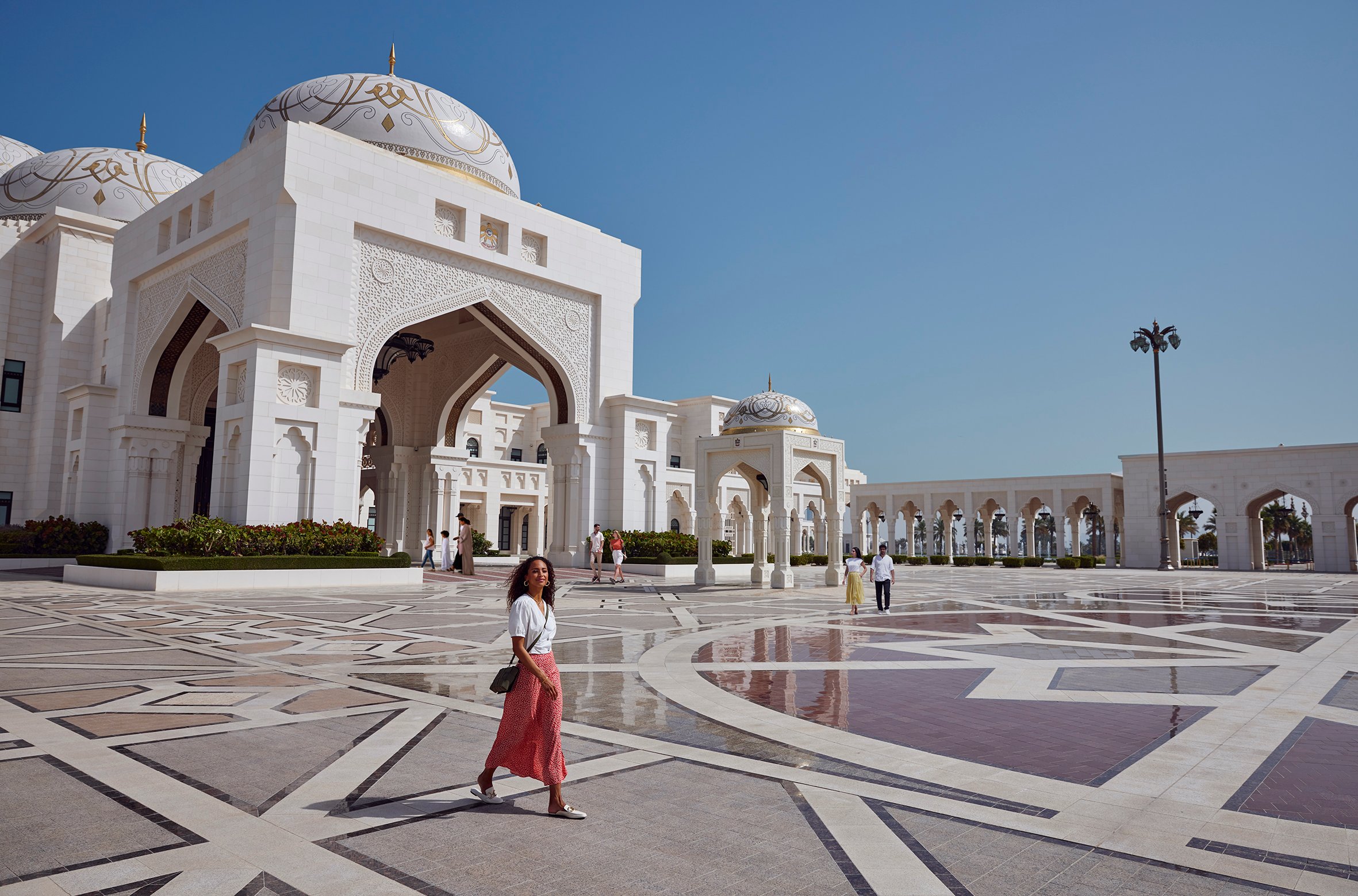 Turisti passeggiano nel cortile del Palazzo Presidenziale Qasr Al Watan, luogo di riferimento per il patrimonio culturale di Abu Dhabi dalla classica architettura islamica