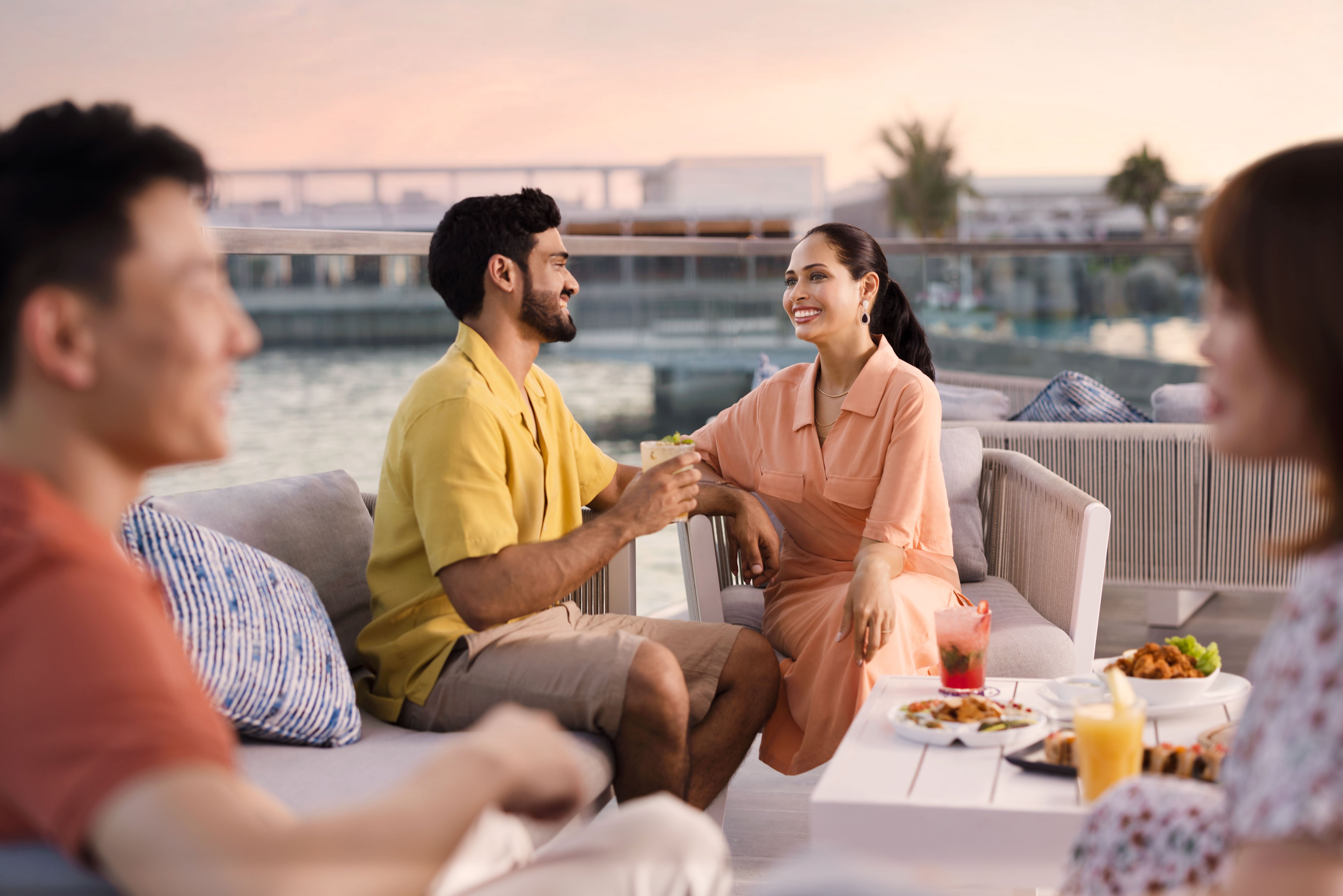 Groupe d'hommes et de femmes souriant et profitant de l'extérieur à Abu Dhabi, montrant le bonheur et l'unité dans le style de vie des adultes.