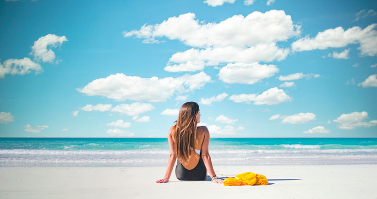 Relaxing by the pristine beach in Abu Dhabi under a clear blue sky, enjoying serene coastal vibes.