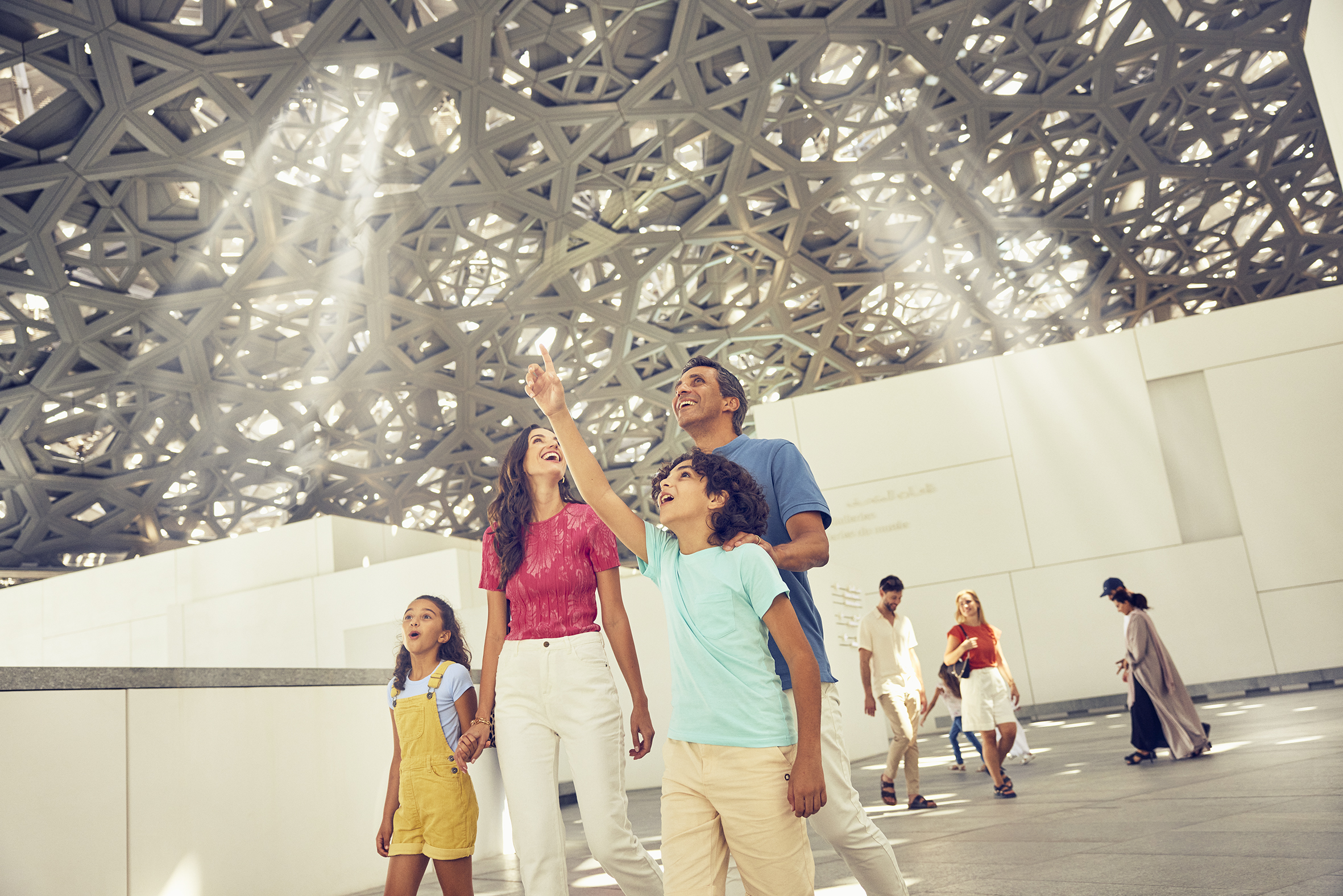 Western family marveling at the dome above the Louvre Abu Dhabi