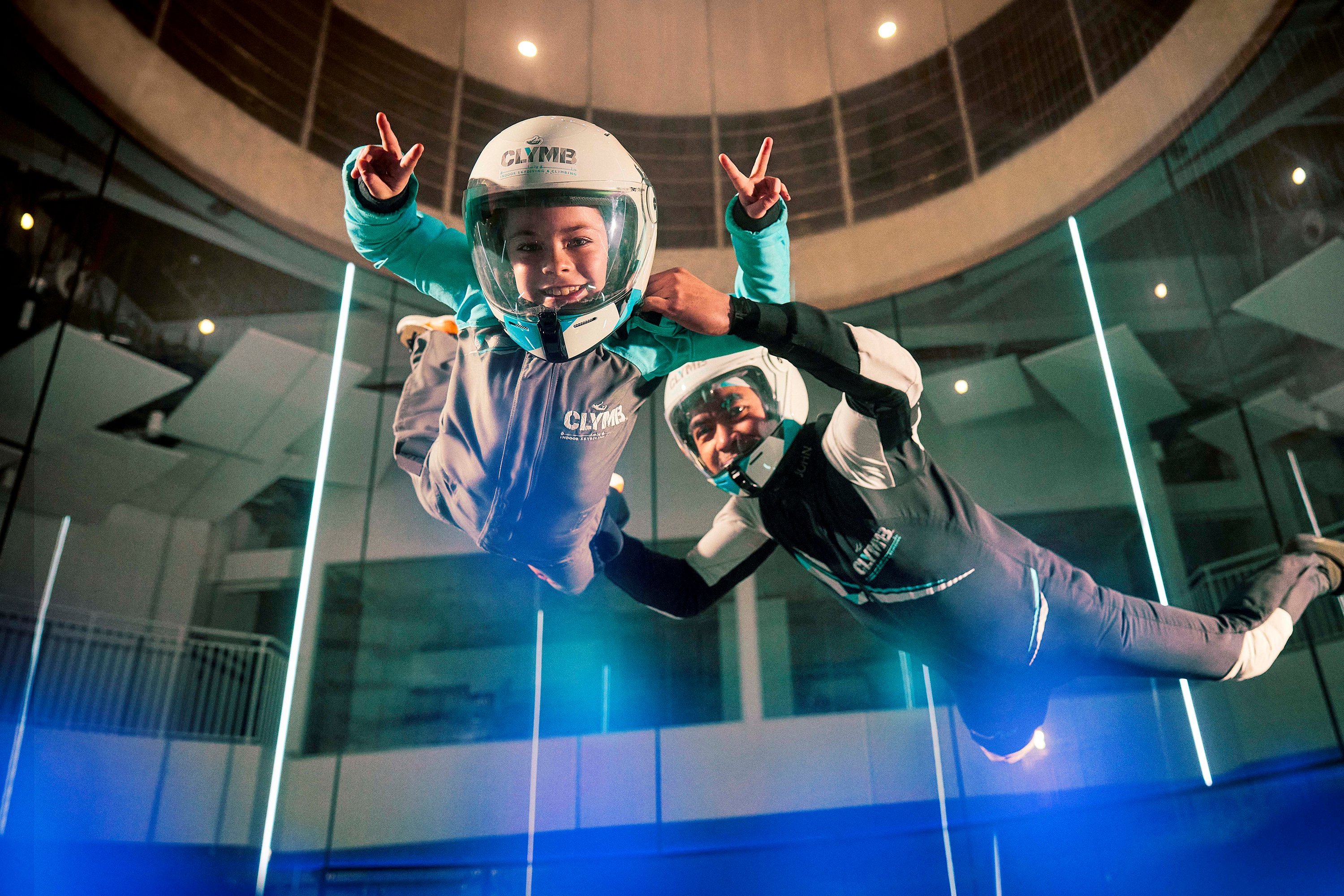 Two children flying in the indoor skydiving wind tunnel