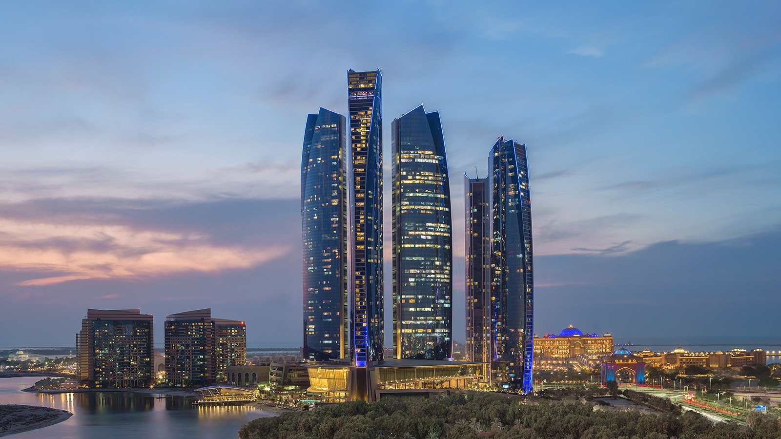 Vue crépusculaire de la célèbre ligne d'horizon urbaine d'Abu Dhabi, composée de gratte-ciel et de structures bâties.