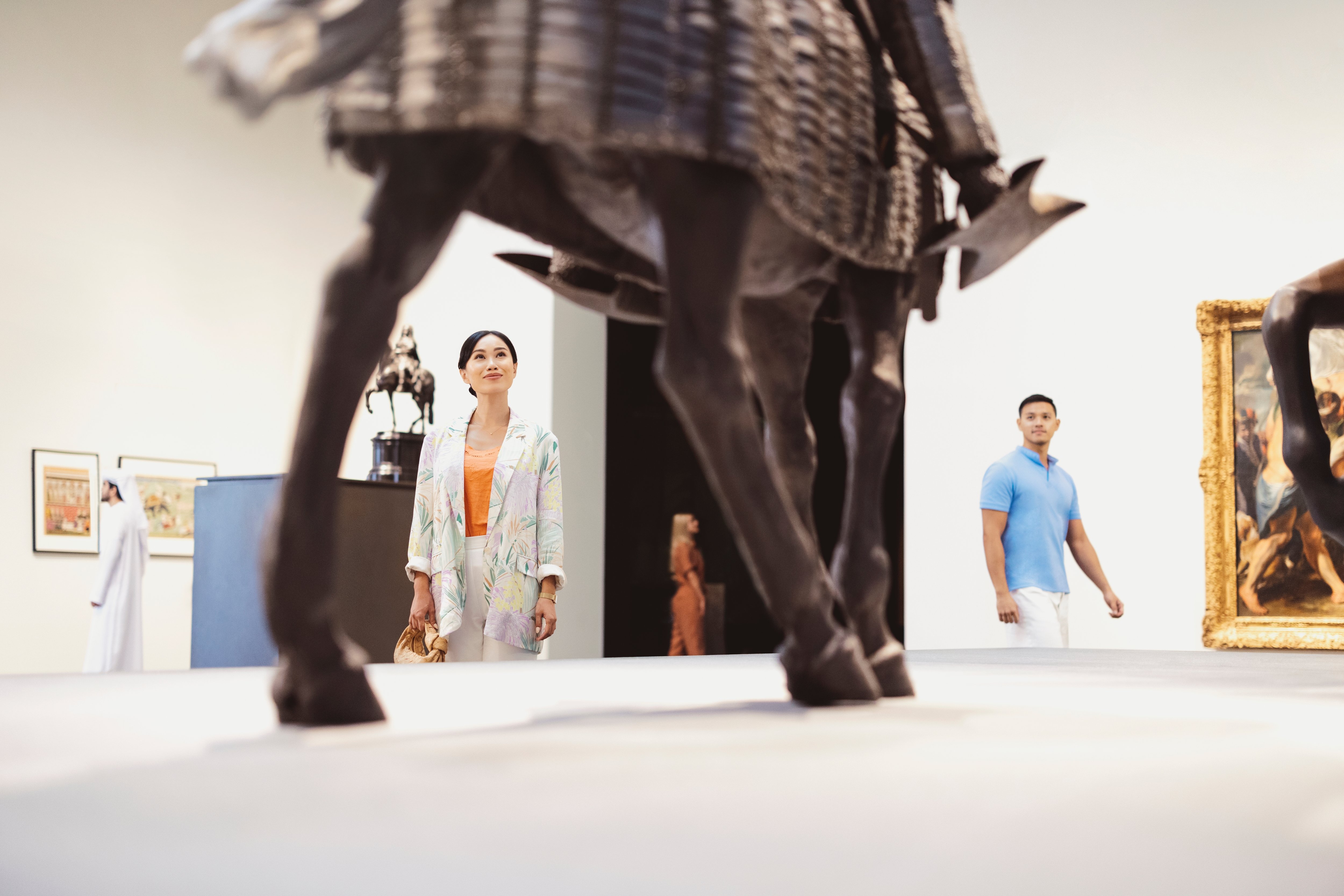 زوجان آسيويان يتأملان مجسمًا في متحف اللوفر أبوظبي