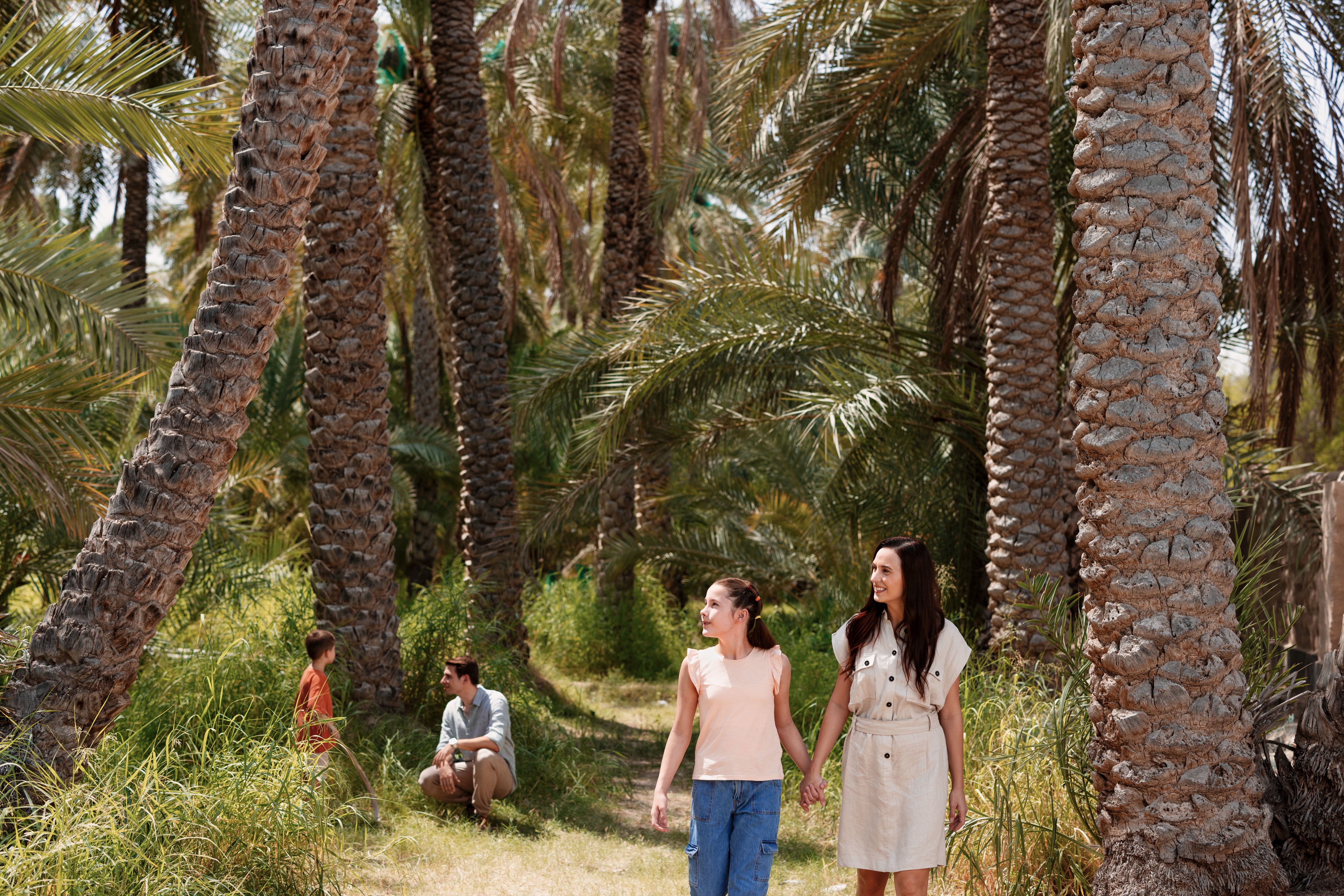 Western family enjoying their time in a lush green oasis in Al Ain