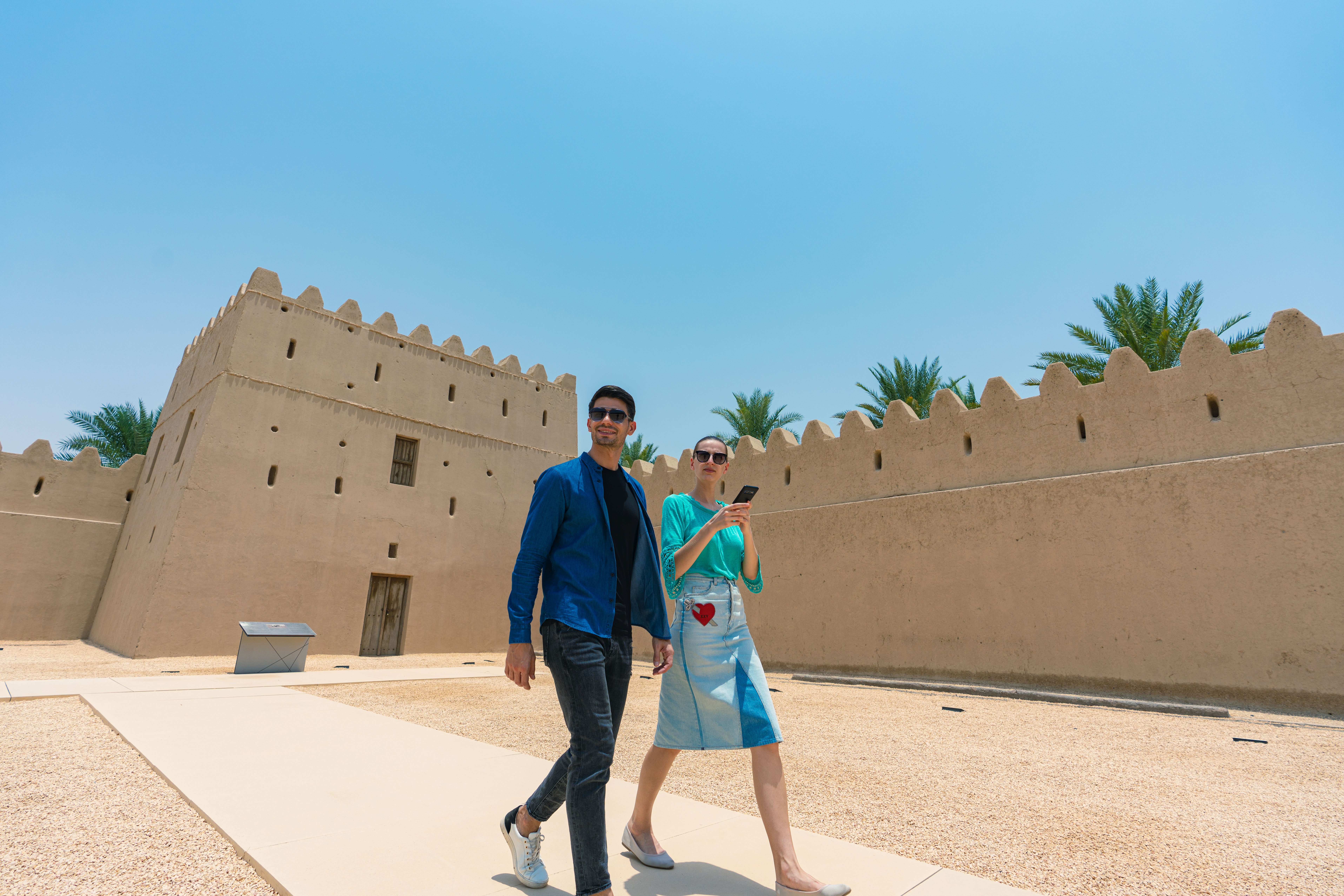 A couple walking in the courtyard at Qasr Al Muwaiji
