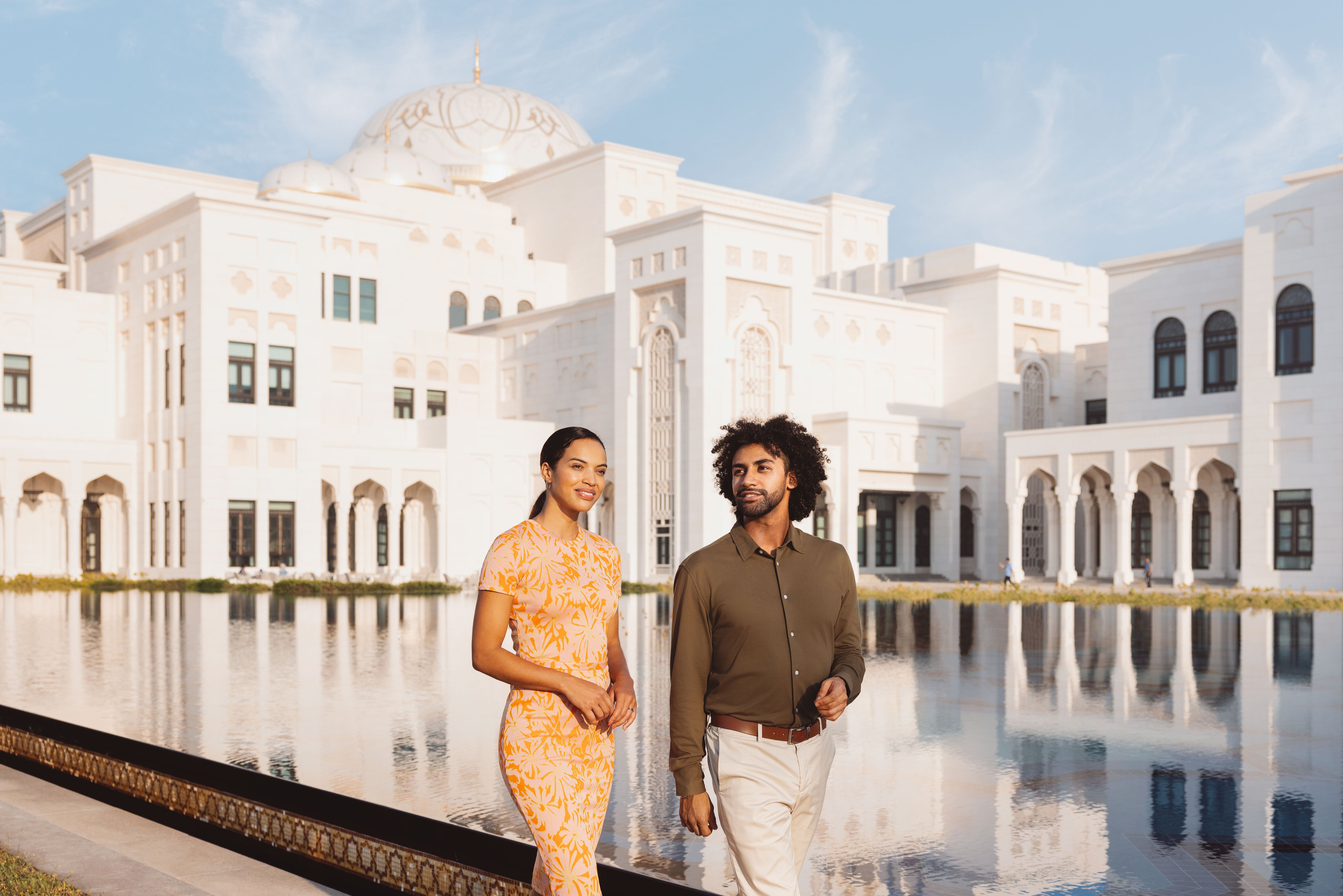 Couple walking outside by the water at Qasr Al Watan palace
