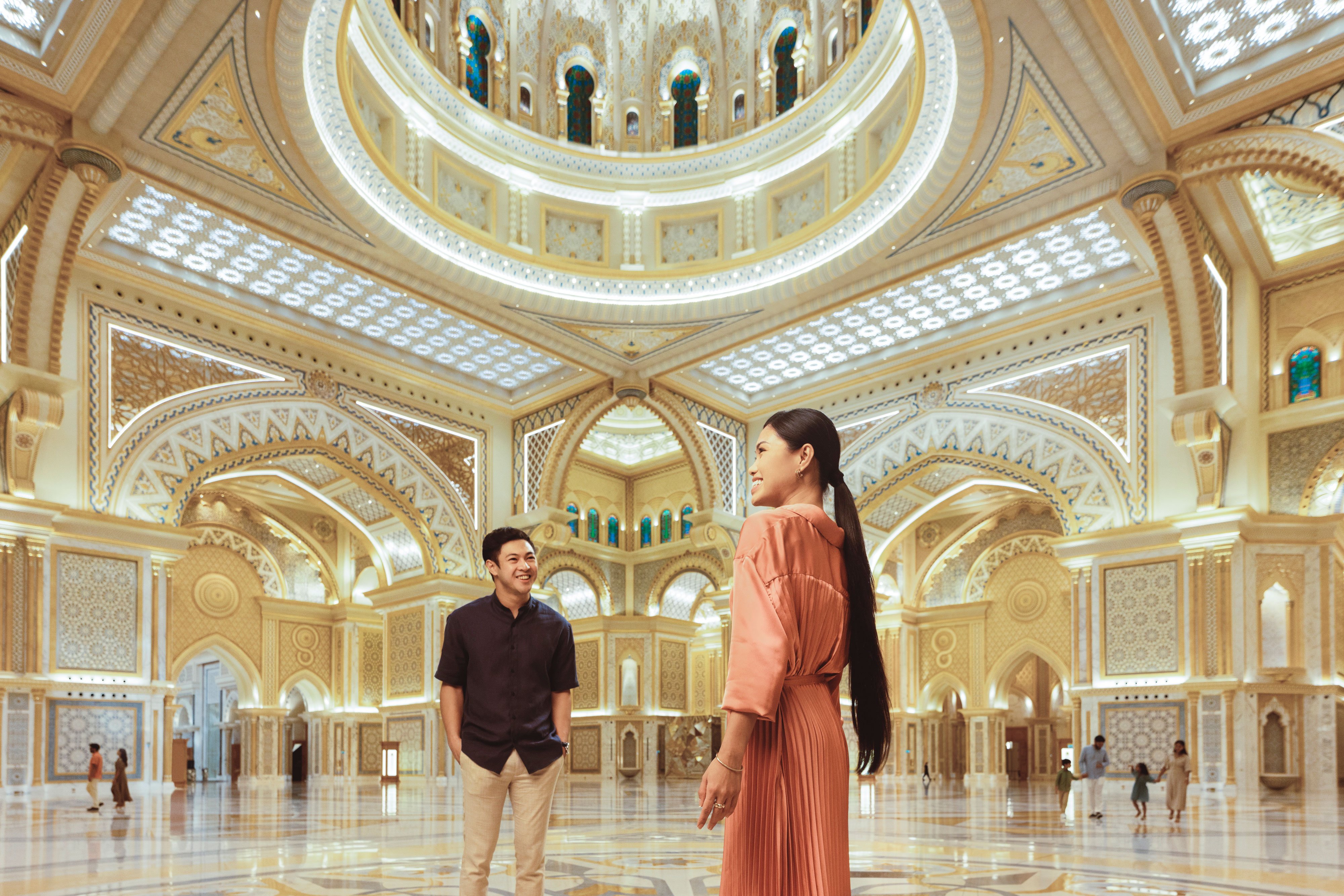 Asian couple smiling and looking at the architecture in Qasr Al Watan