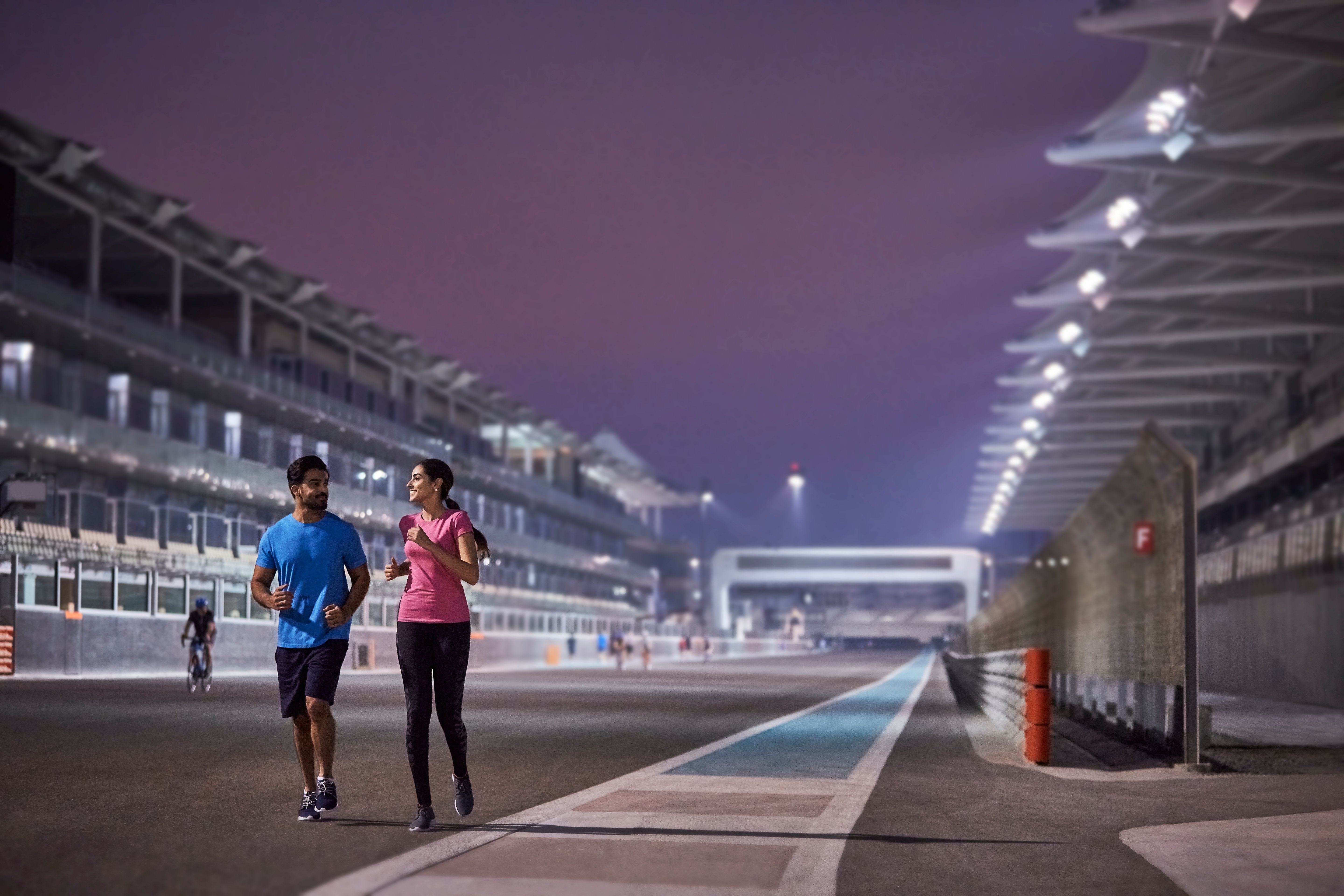 Couple running together on the tracks at Yas Marina Circuit