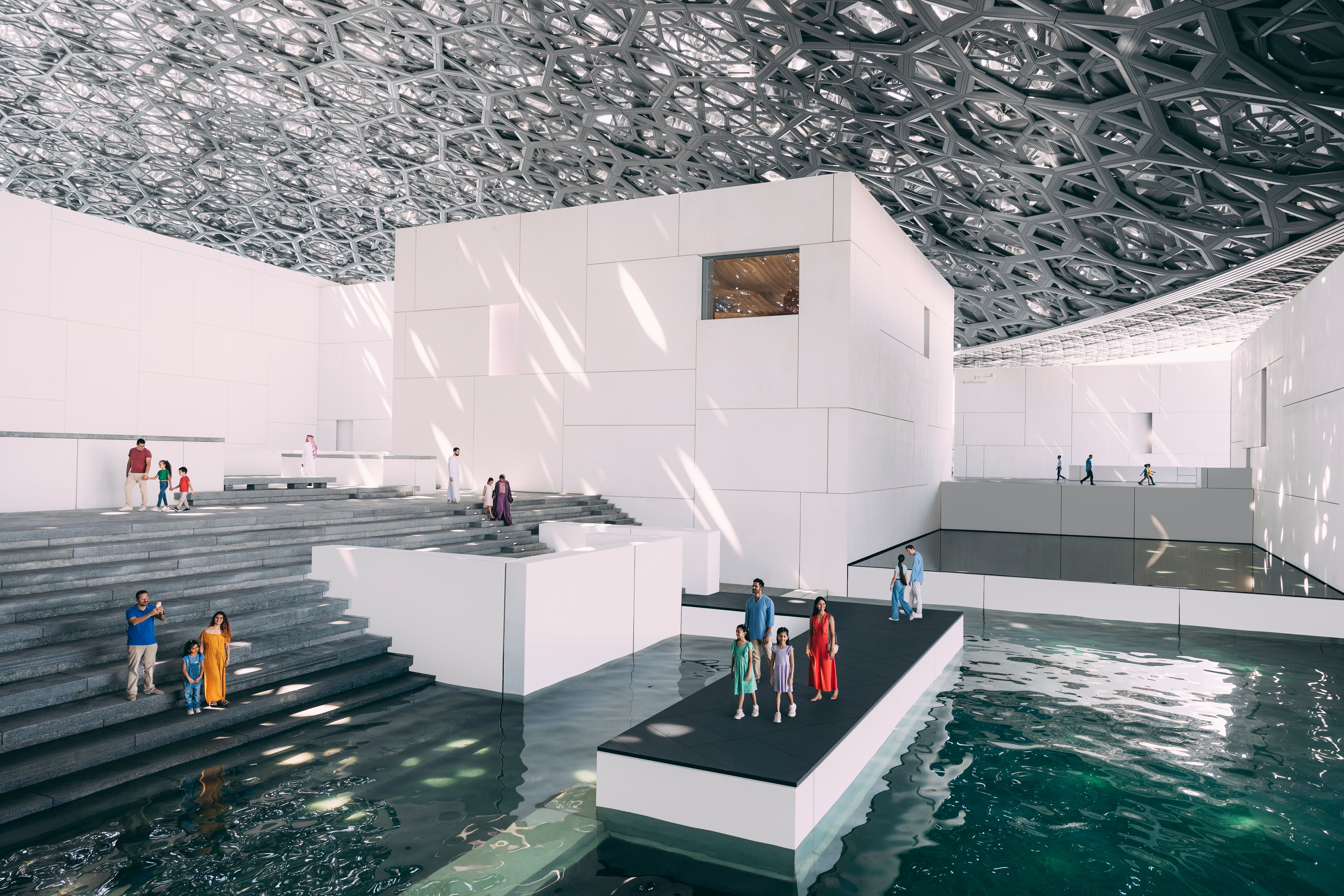 Various tourists standing outside the Louvre Abu Dhabi water displays