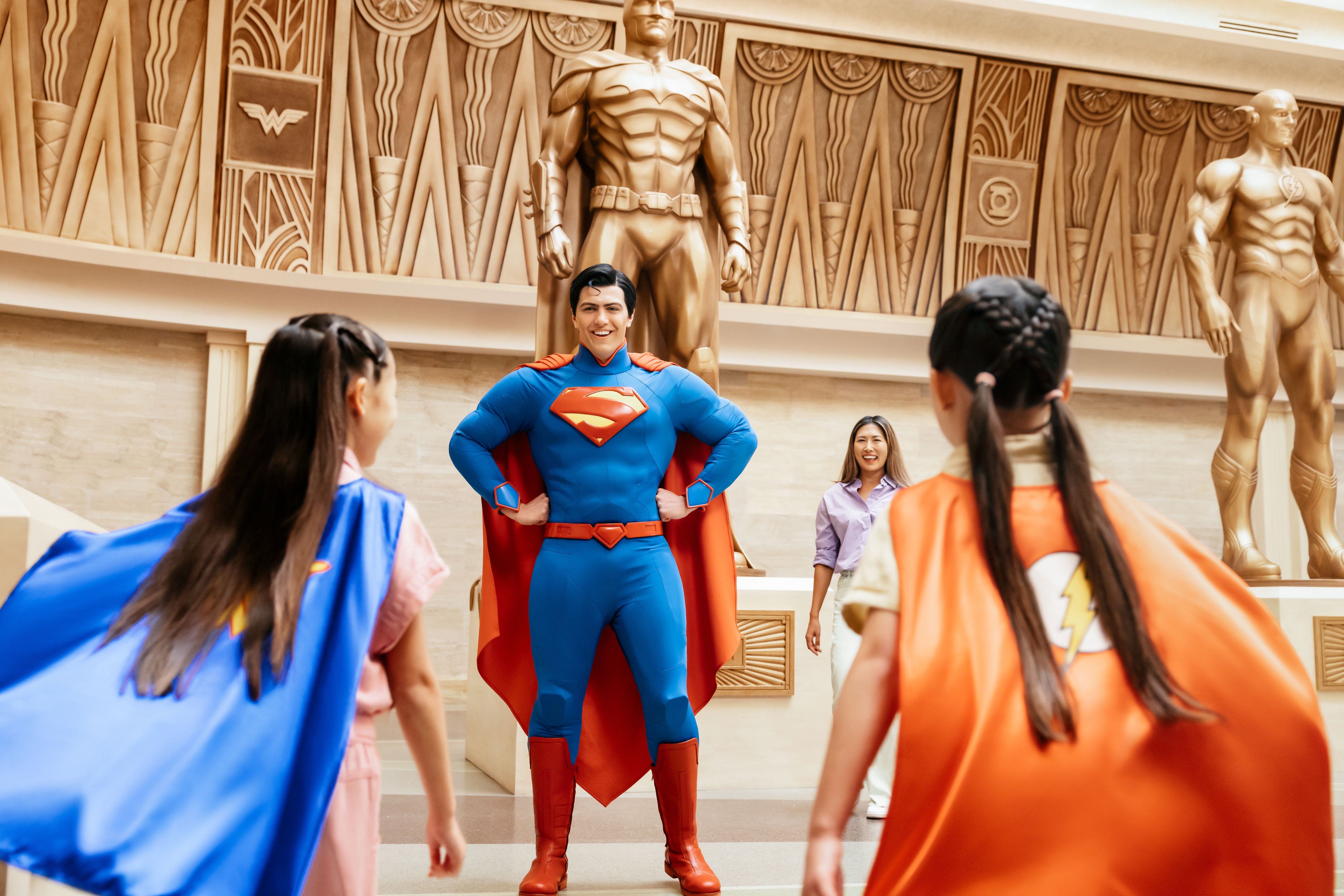 Man wearing a Superman costume in front of two girls at Warner Bros World Abu Dhabi