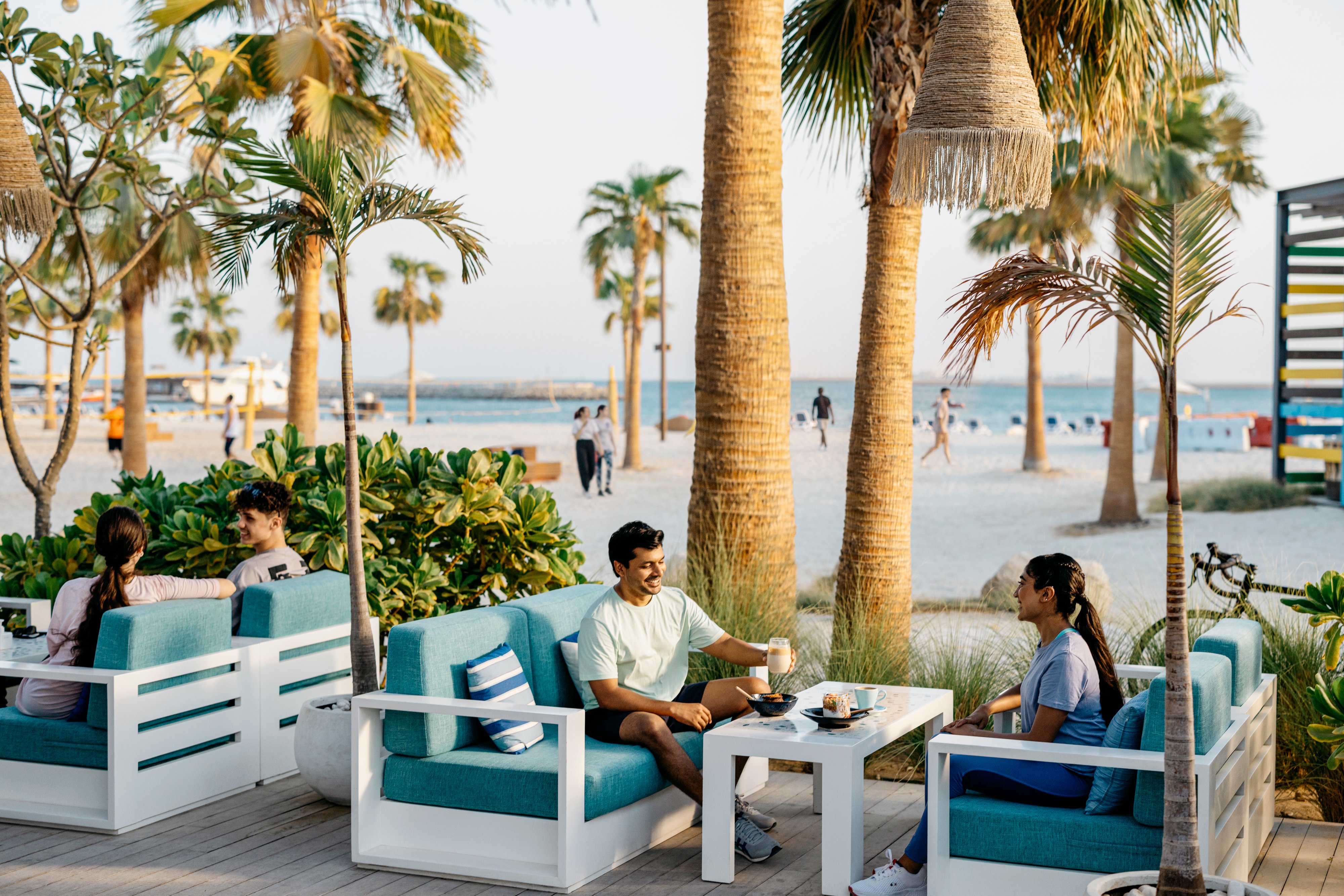 Man and woman enjoying coffee near the beach on Hudayriyat island