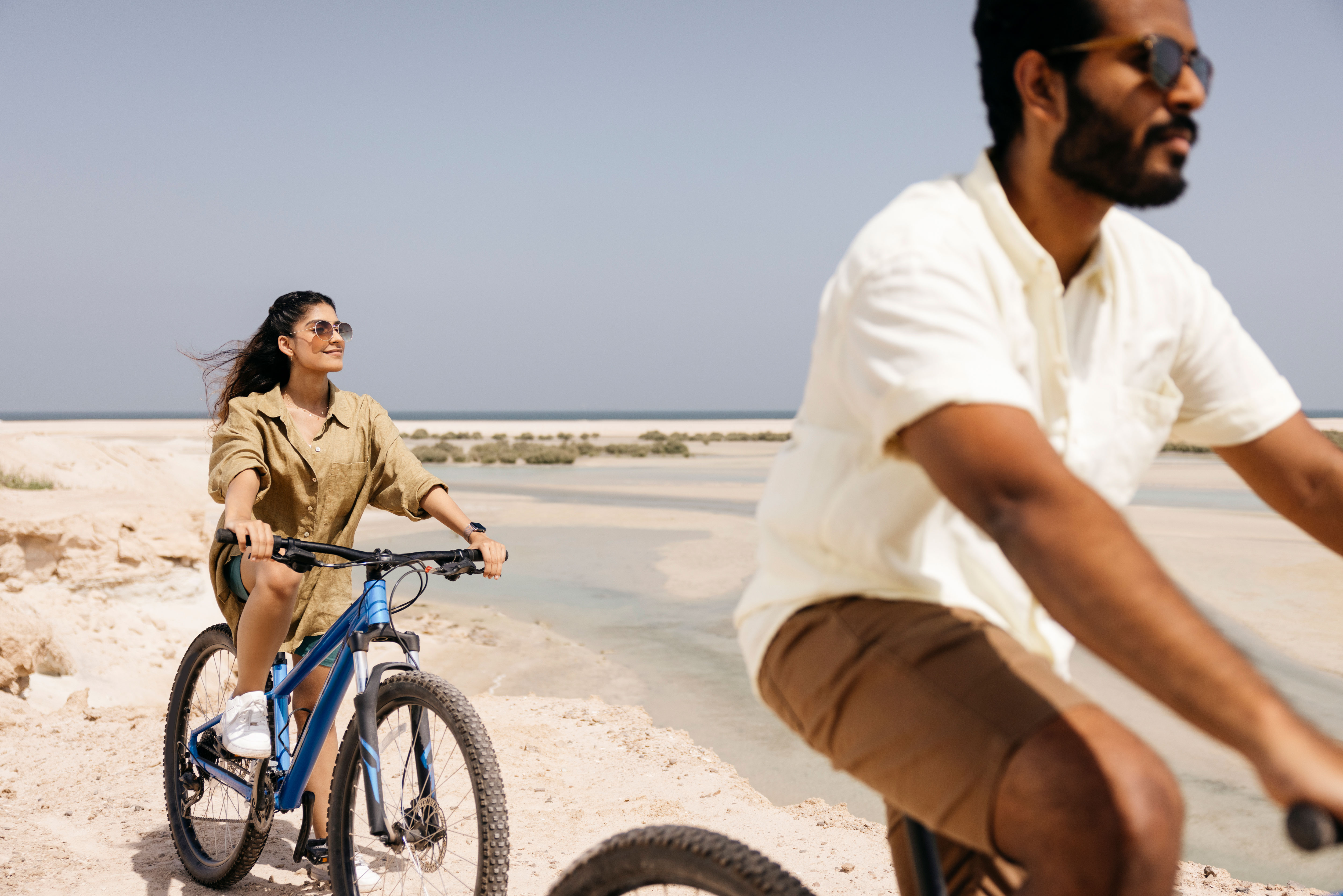 Asian couple adventuring on mountain bikes on Hudayriyat island