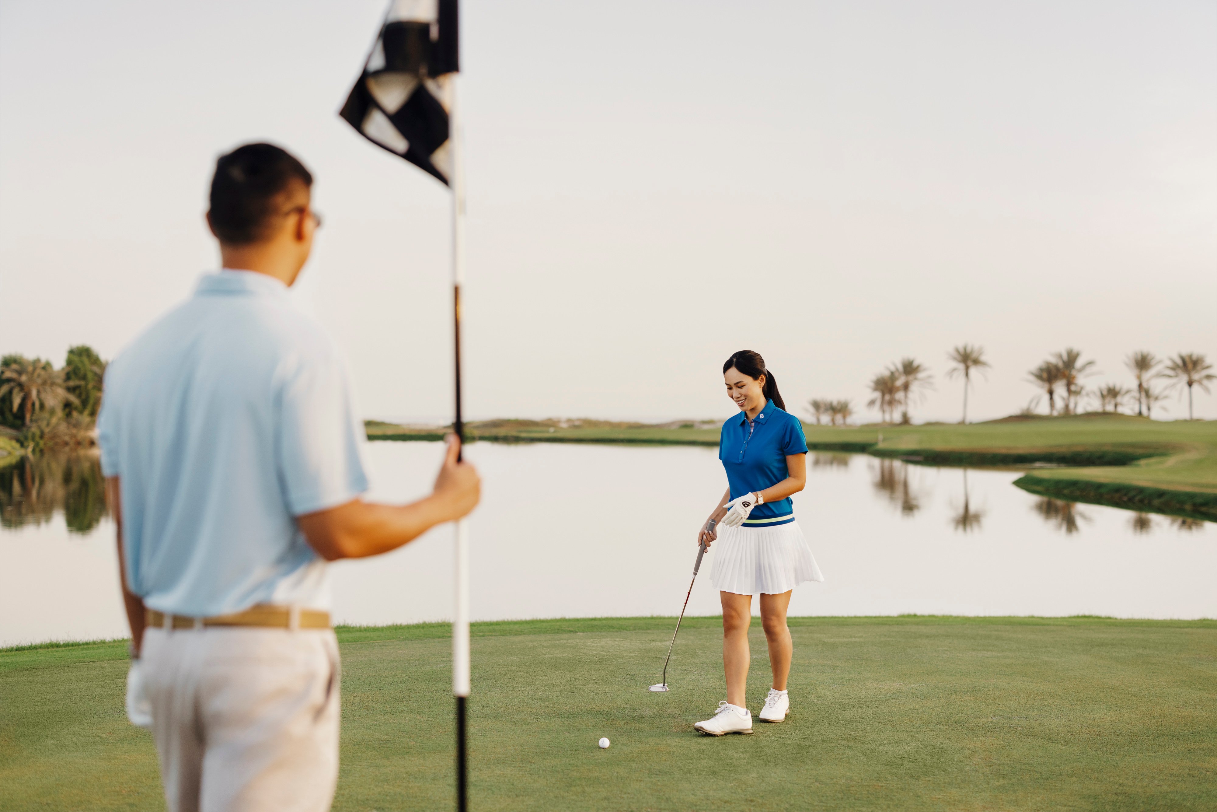 Couple playing golf at Saadiyat Beach Golf Club