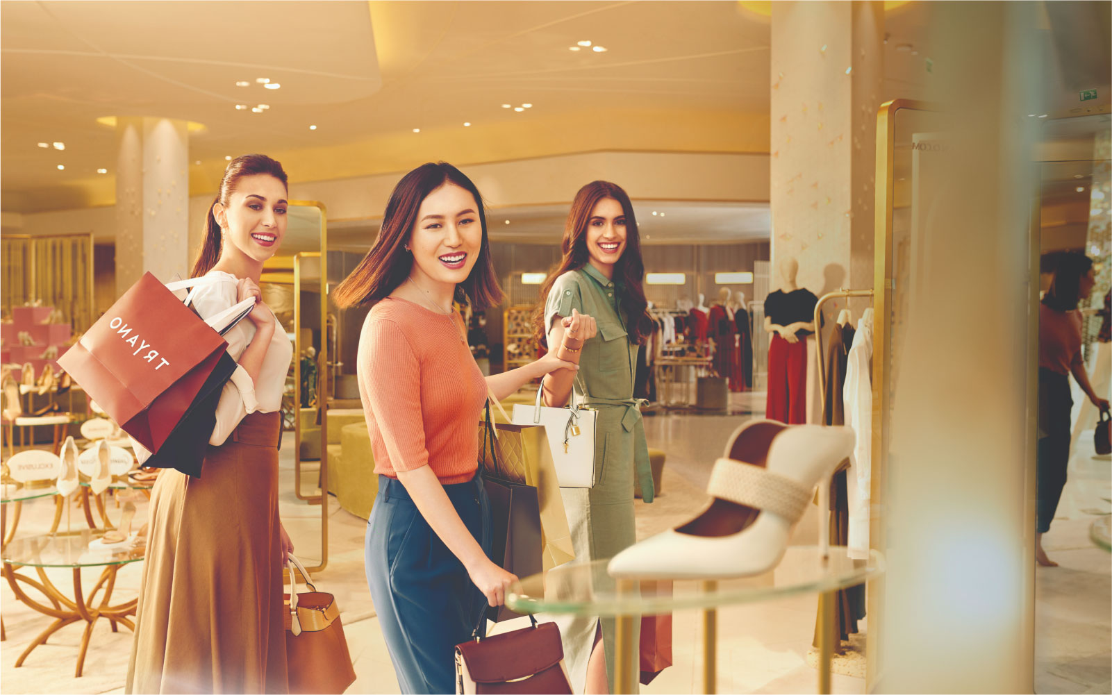 ثلاثة نساء يستمتعن بالتسوق في ياس مول
