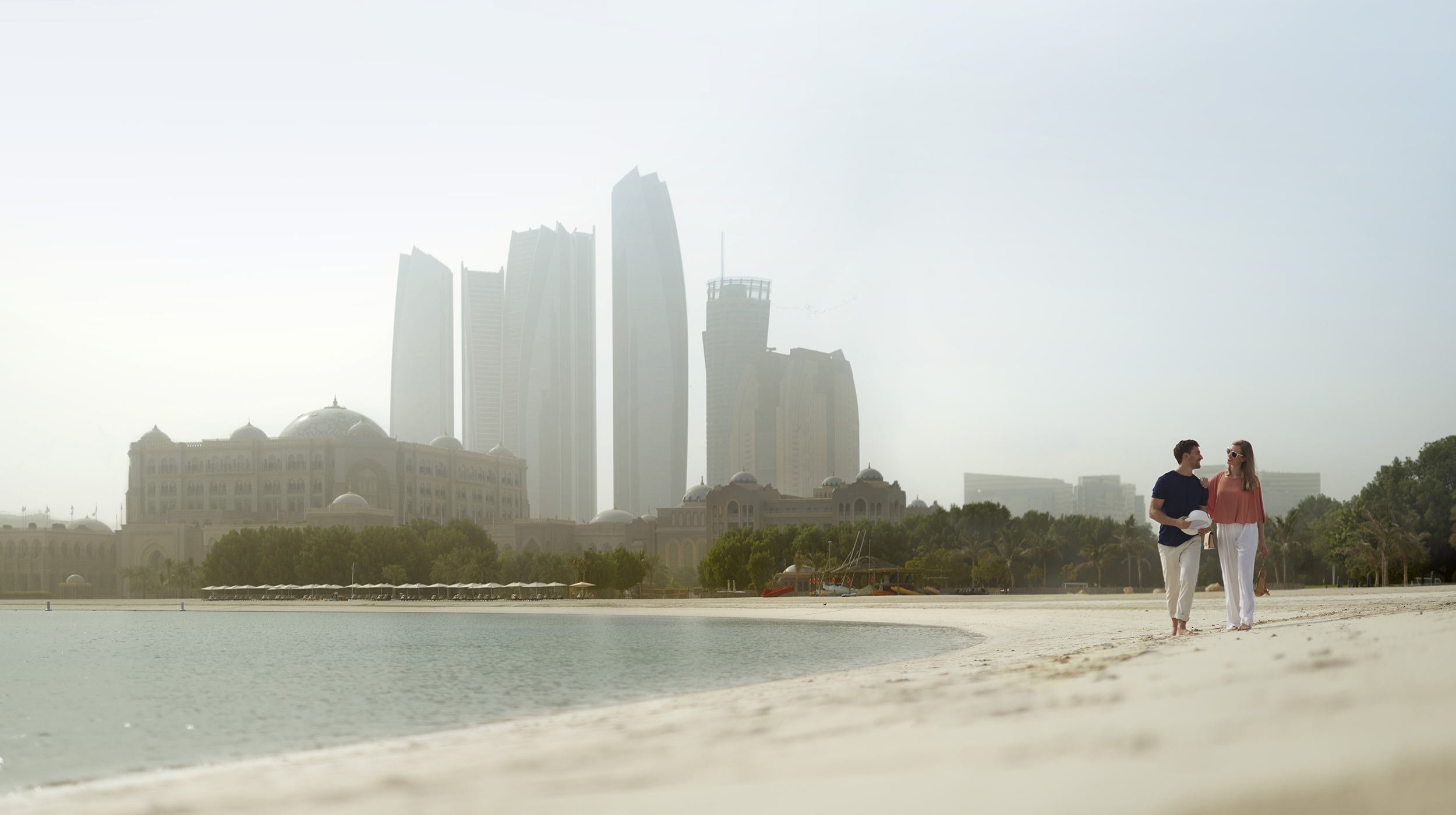 Western couple walking on the beach at Emirates Palace Marina